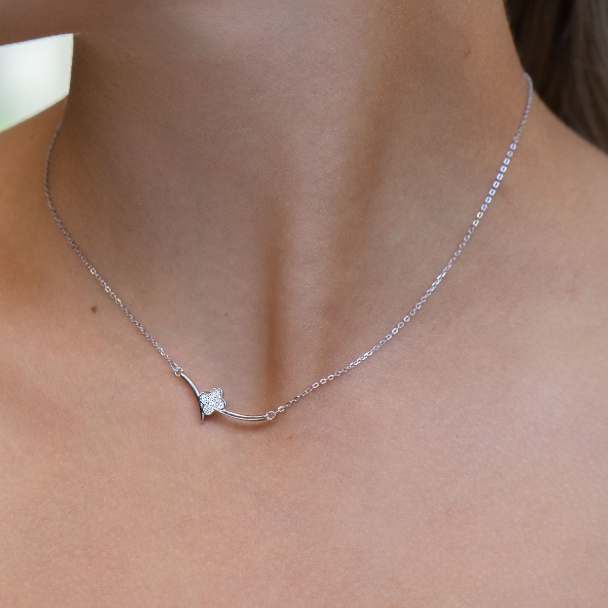 Fine women's necklace with clean shapes and a delicate clover in the center. The softness of the silver and the discreet shine of the zircons give the necklace a special charm.