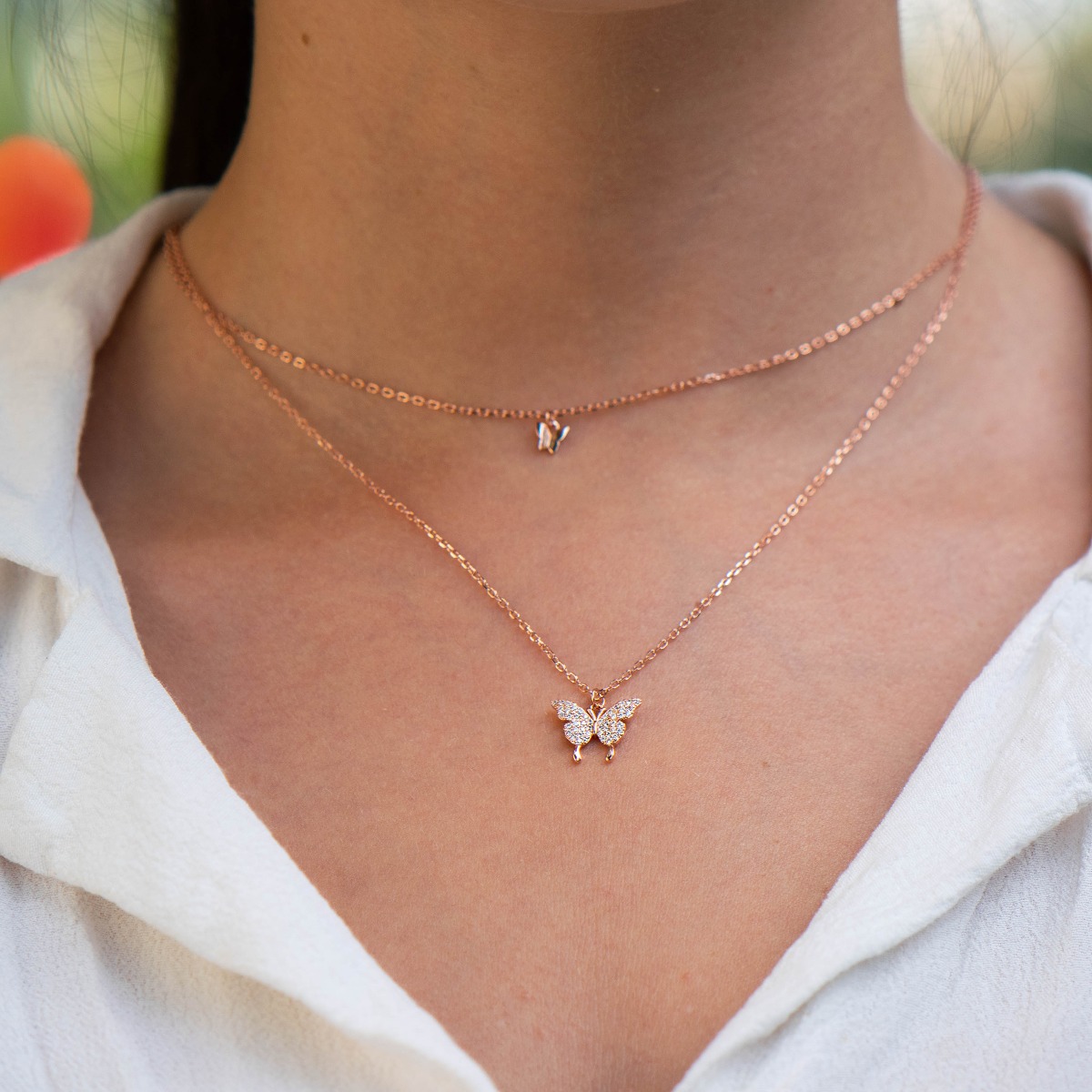 Tempting creation of women's necklace in fine rose silver with delicate butterflies and countless glittering zircons. The dainty butterflies are set on two rows of rose silver chains, and the extra extension allows the length to be adjusted.