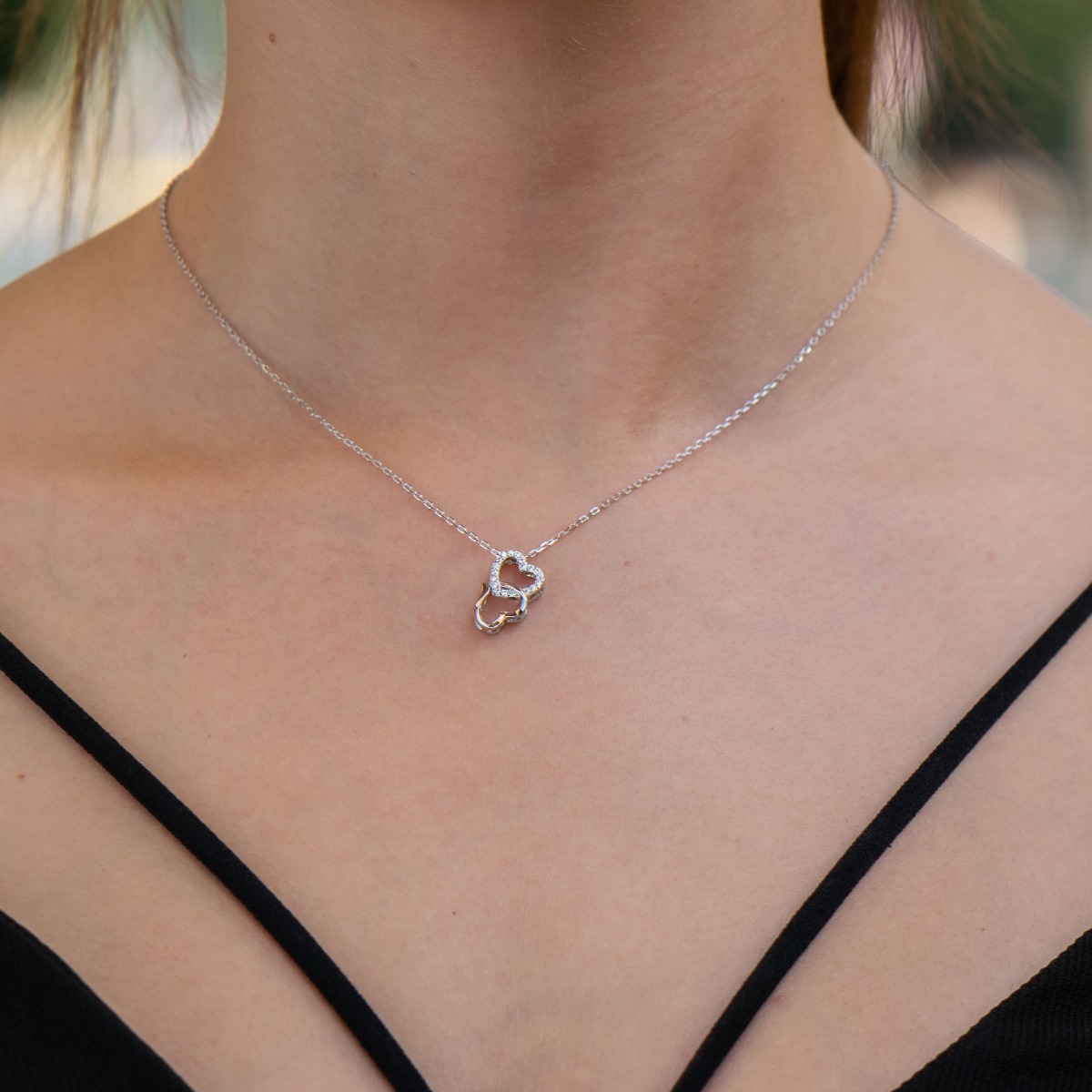 Rhodium silver necklace in the shape of two intertwined hearts. A stylish addition to your everyday look.