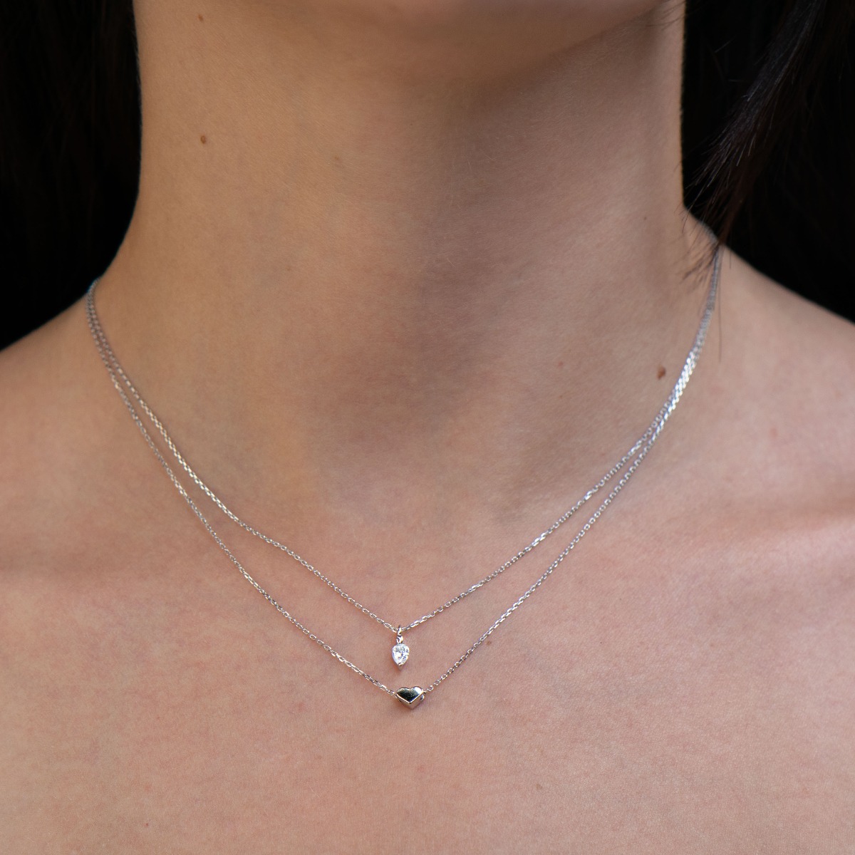 Exquisite design and spectacular pattern of double silver necklace with hearts of soft rhodium silver and dazzling zircon. An original and sought-after piece of jewelry by stylish ladies.