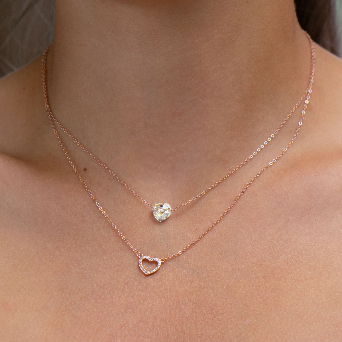 Elegant women's necklace with an exquisite design in rose silver with two delicate hearts. The jewelry has a double chain. A magnetic heart-shaped zircon dances charmingly on one, and on the second the heart is made of silver with added fine stones.