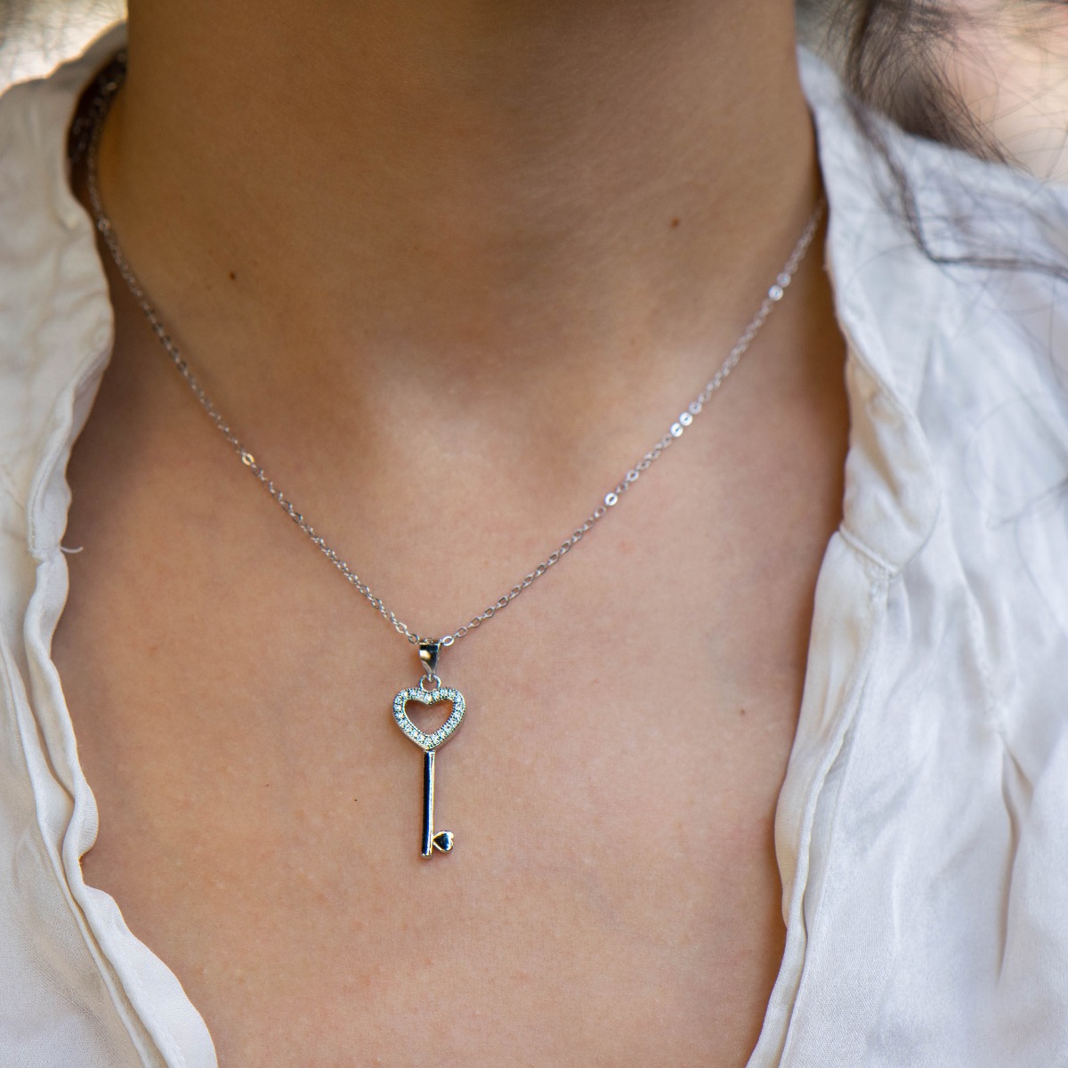 A charmingly beautiful women's key pendant necklace, with a masterful craftsmanship entirely of rhodium-plated silver and added zircons. The key has heart elements, a suitable gift for girls in love.