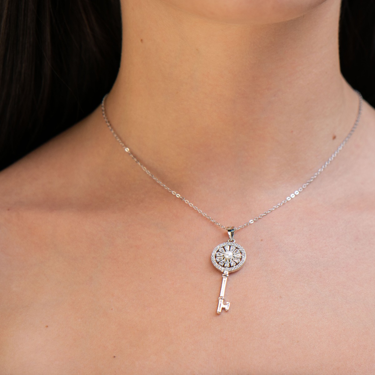 A charmingly beautiful women's key pendant necklace, with a masterful craftsmanship entirely of rhodium-plated silver and zircons, varying in size and shape. A lovely piece of jewellery, a suitable gift for any occasion.