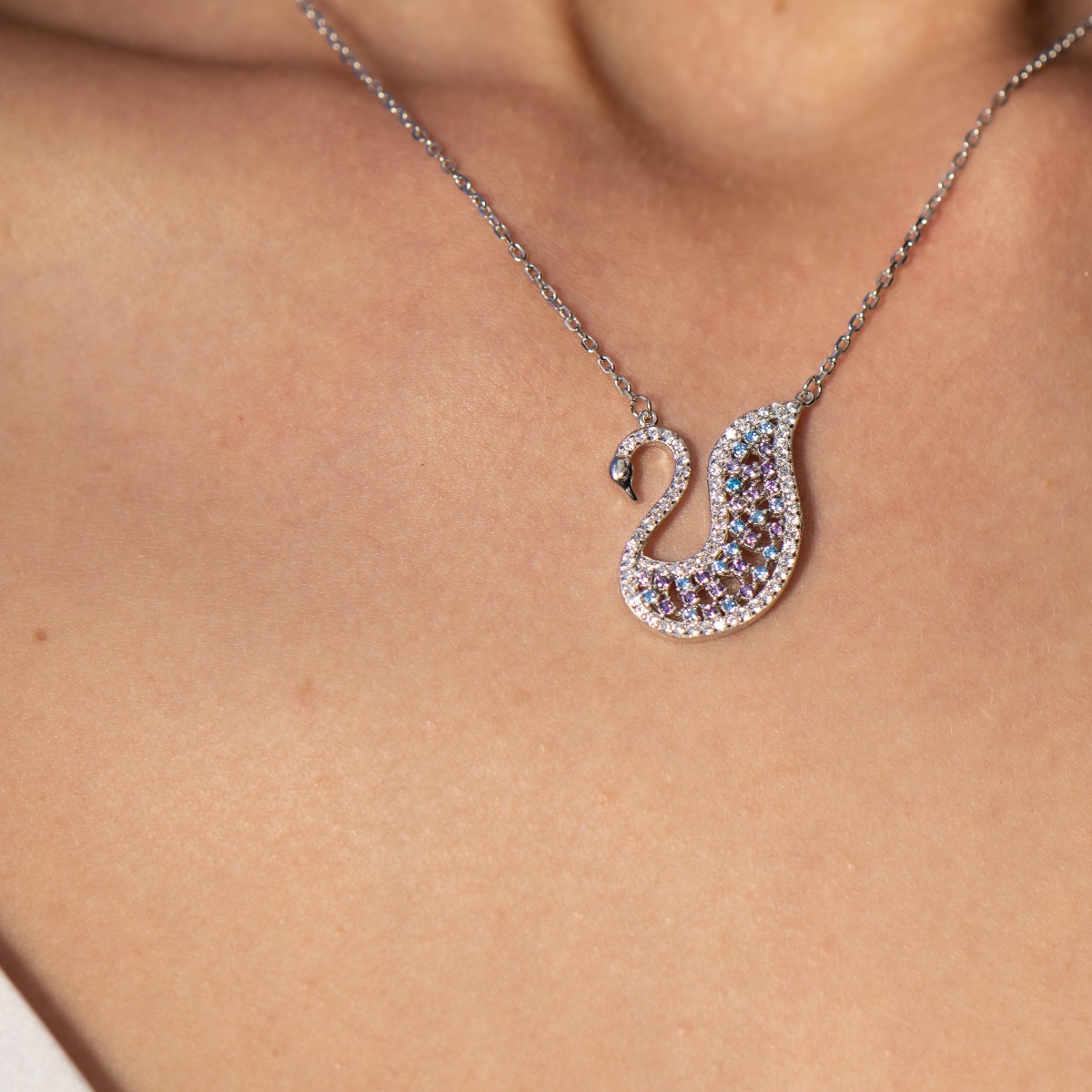 A charming women's necklace with precision craftsmanship entirely in rhodium-plated silver and shaped like a beautiful swan, complemented by glittering patterned stones.