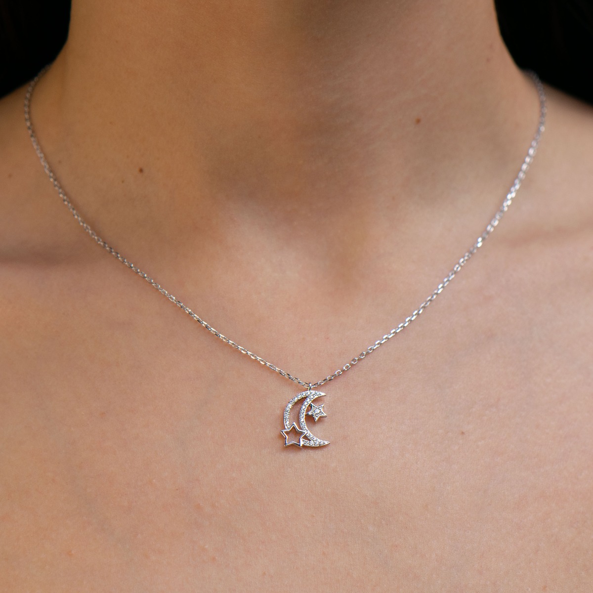 Elegant women's necklace with an exquisite design of rhodium-plated silver. The jewelry is of unique craftsmanship - a gentle moon, fully decorated with zircons, charmingly shines in the company of glittering stars.