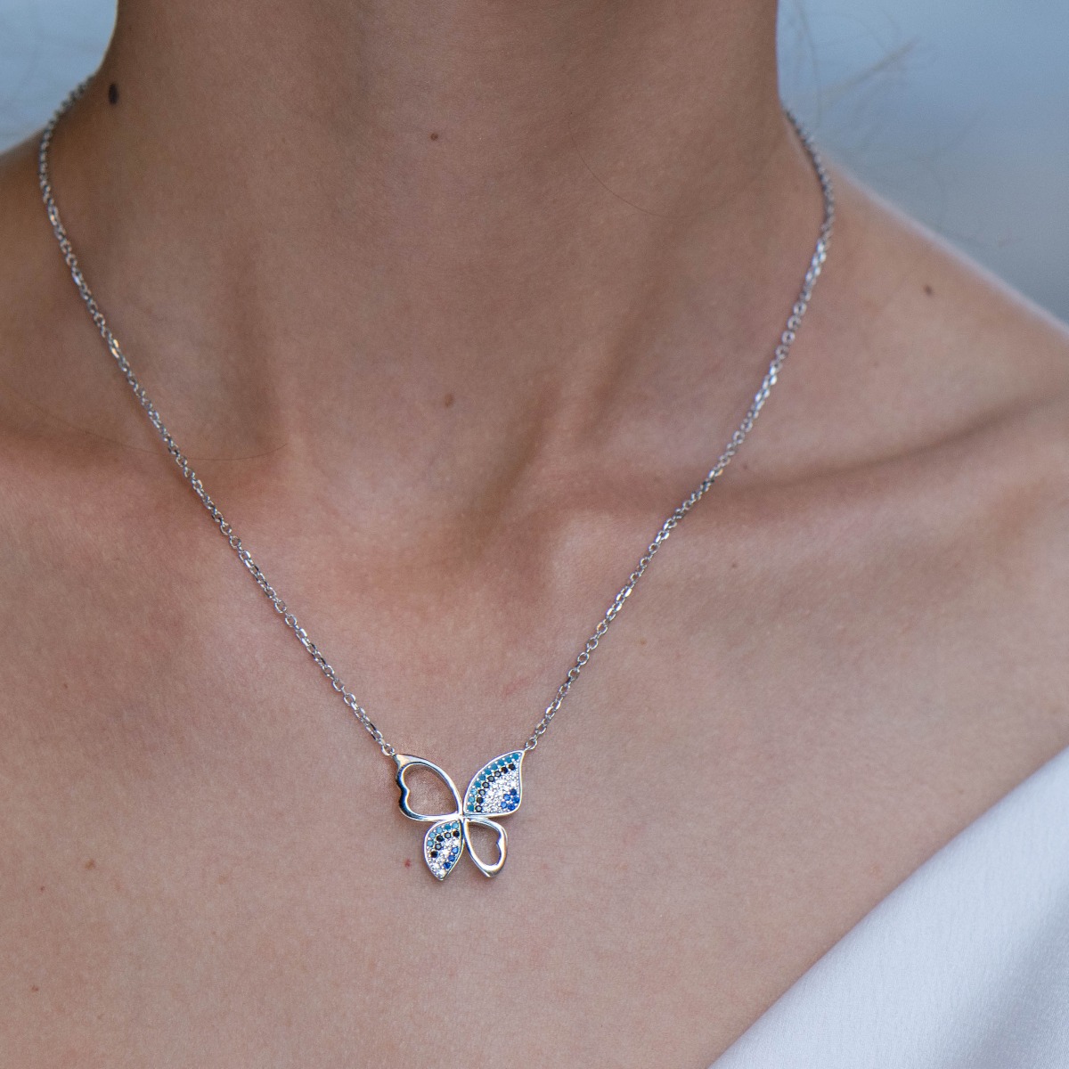 Delicate butterfly charm lies within this necklace, meticulously crafted from rhodium-plated sterling silver and countless glittering multi-colored zircons.