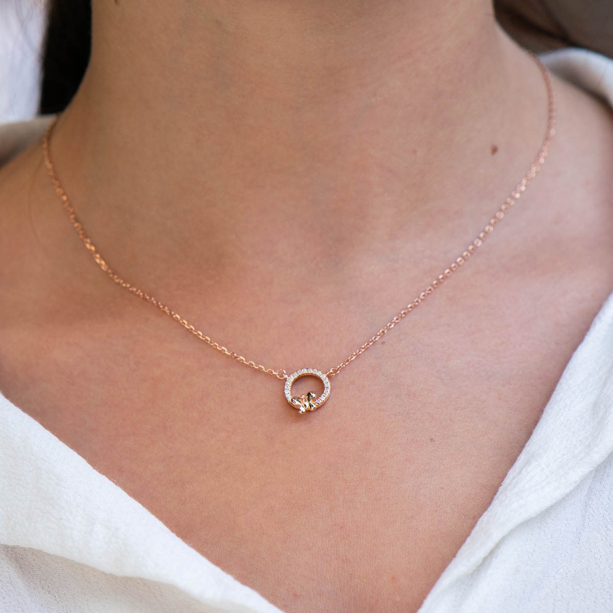 A lovely necklace in soft rose silver, with an elegantly shaped circle, all studded with sparkling zircons. A small, delicate butterfly is perched timidly on the stones. The necklace is an ideal gift to please a friend or beloved woman.