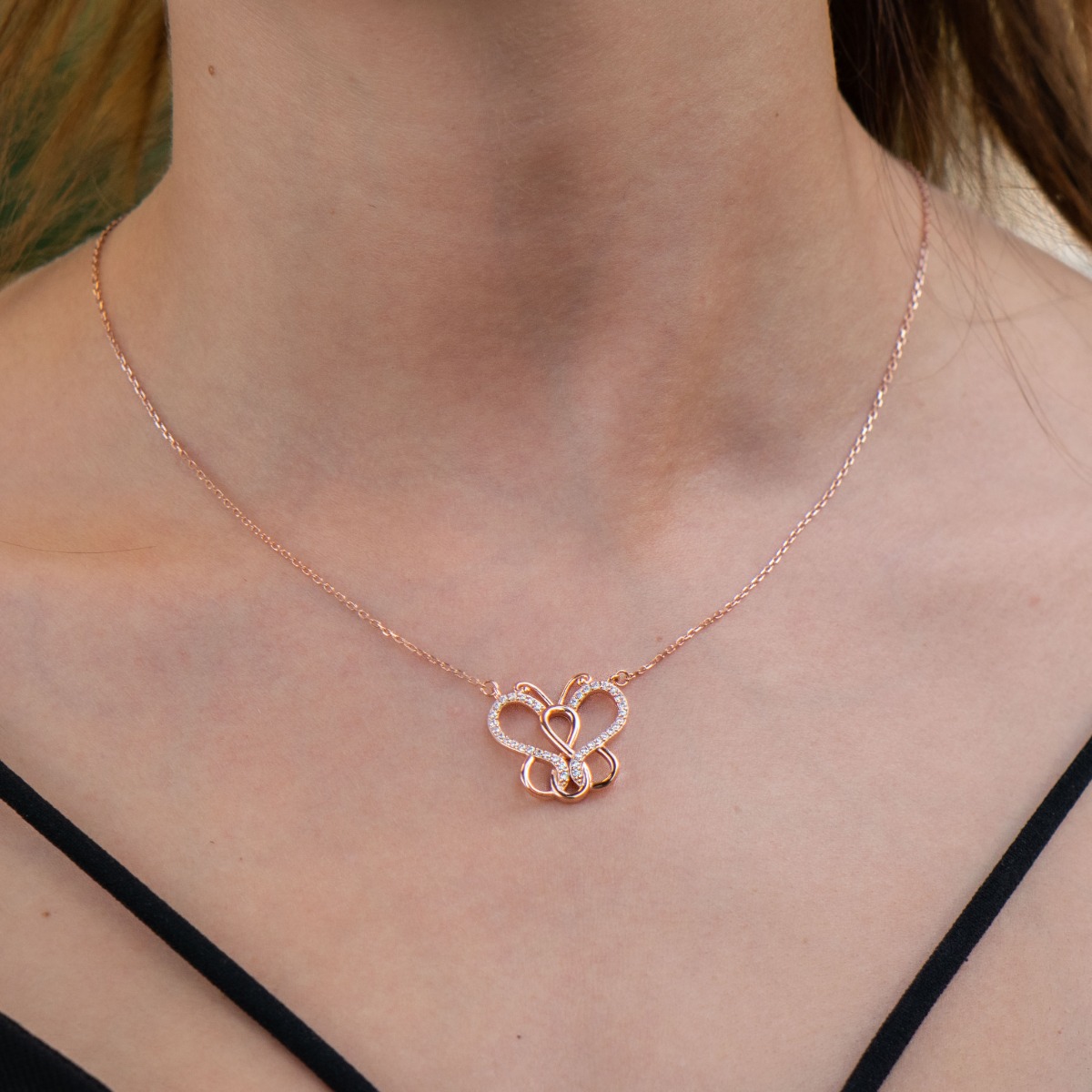 An exquisite women's necklace with delicate workmanship entirely of rhodium-plated rose silver, complemented by sparkling zircons and a delicate butterfly shape.