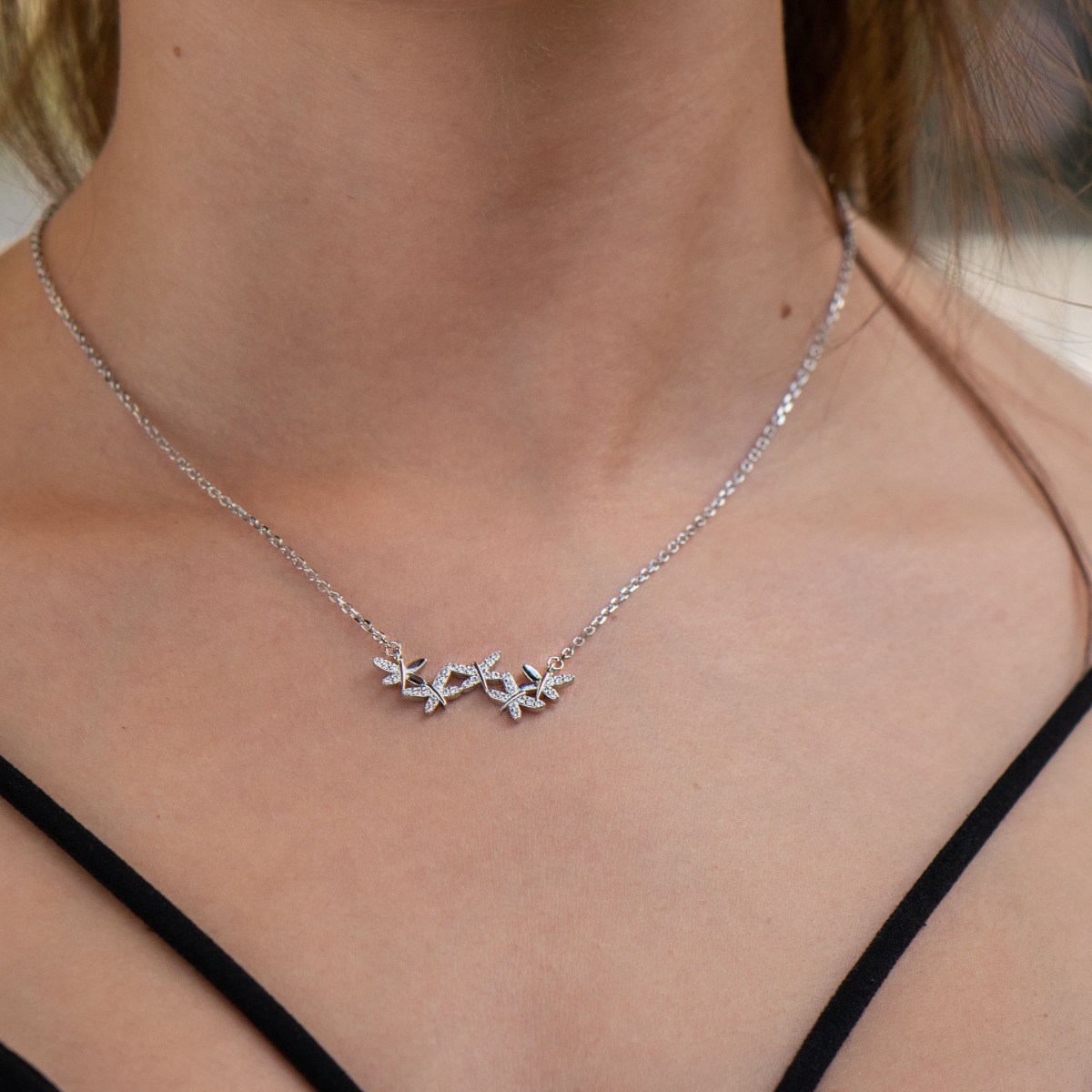 Spectacular women's necklace with precise and fine workmanship entirely of soft rhodium silver, complemented by sparkling zircons and an exquisite shape of numerous small butterflies.