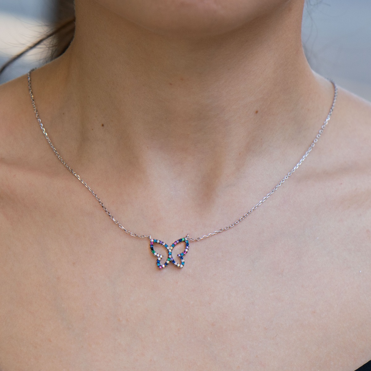 Spectacular women's necklace with modern craftsmanship entirely of rhodium-plated silver and the shape of a beautiful butterfly, studded with glittering multi-colored zircons.