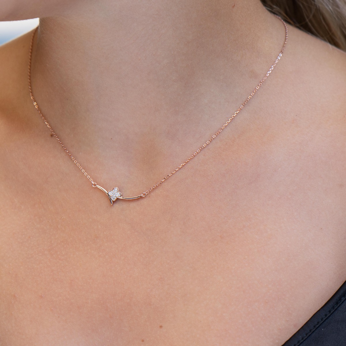 Fine women's necklace with clean shapes and a delicate clover in the center. The softness of the rose silver and the discreet shine of the zircons give the necklace a special charm.