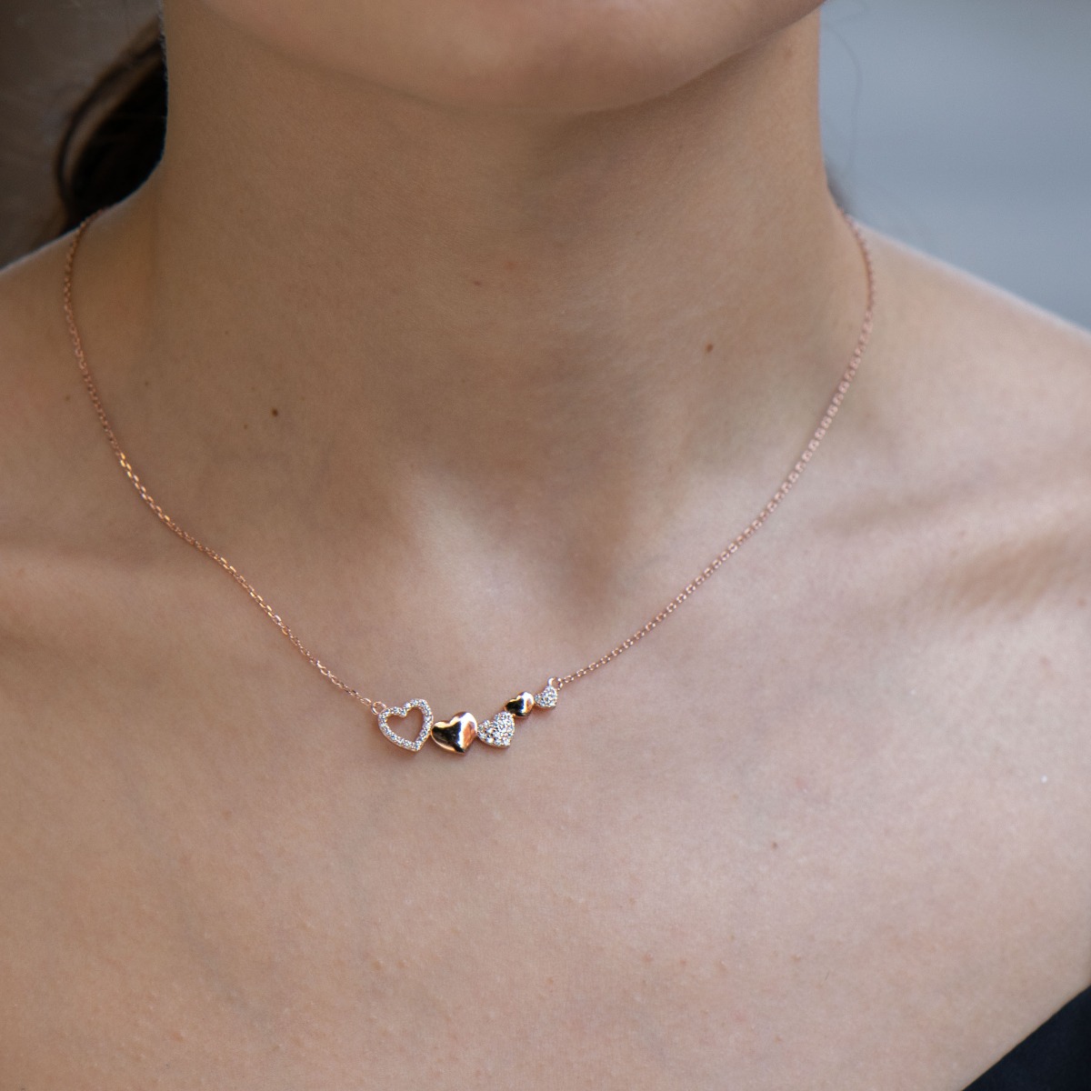 Lovely women's necklace - a row of several tender hearts. Crafted entirely from sparkling rhodium-plated rose silver with countless beautiful cubic zirconias.