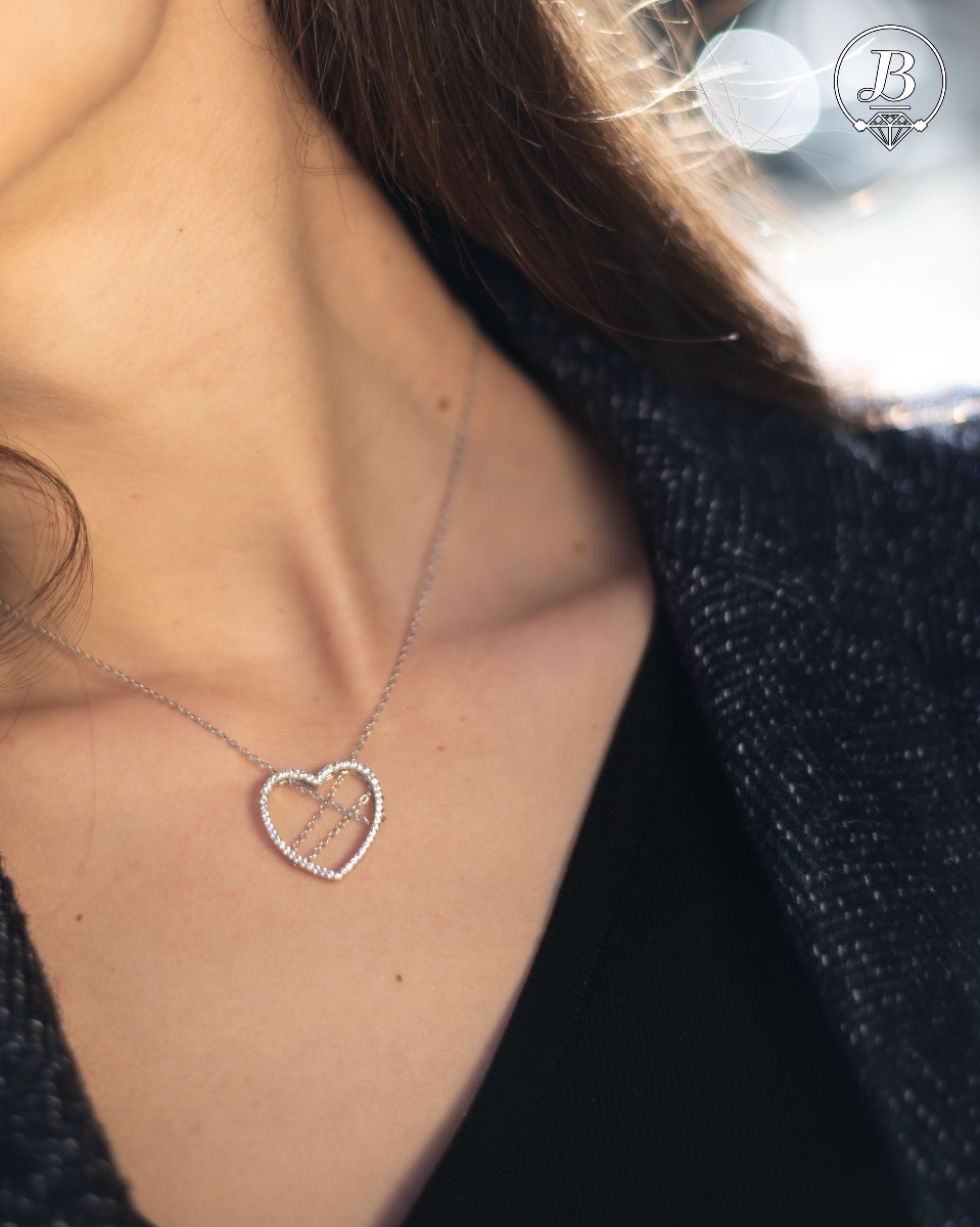 Spectacular silver necklace with exquisite workmanship entirely of rhodium-plated silver and a large heart, complemented by glittering zircons and a spectacular tangled chain.