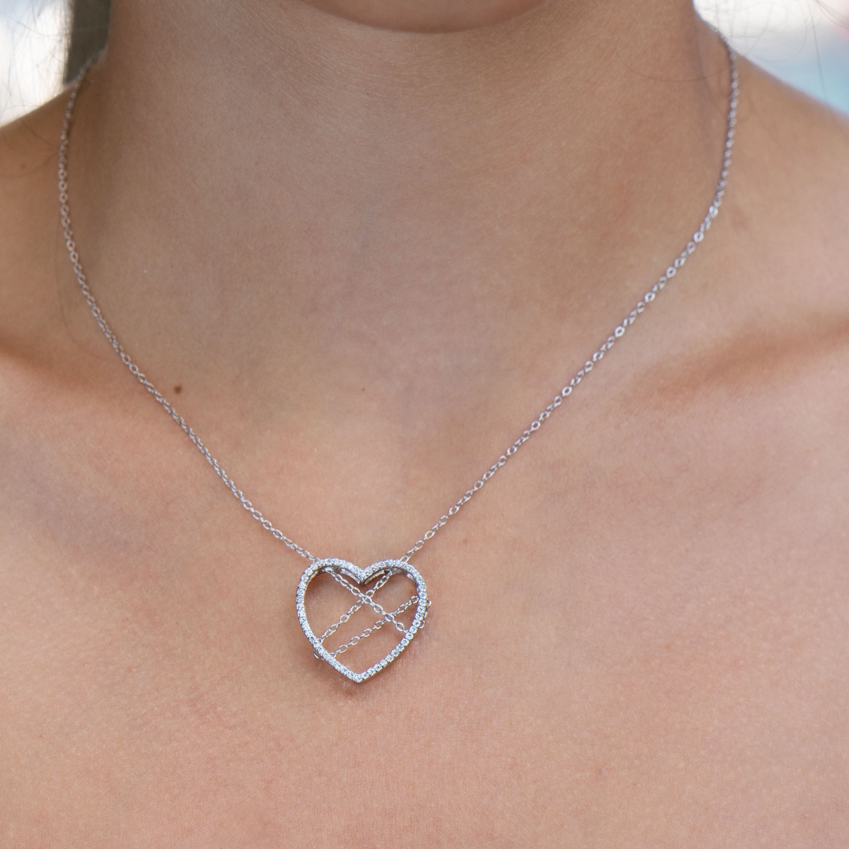 Spectacular silver necklace with exquisite workmanship entirely of rhodium-plated silver and a large heart, complemented by glittering zircons and a spectacular tangled chain.