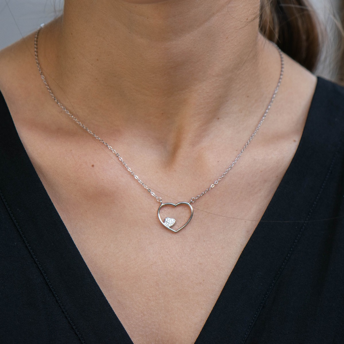 A delicate silver necklace with a delicate heart, complemented by a smaller heart of sparkling zircons. Beautiful design and precision craftsmanship entirely in rhodium-plated silver.