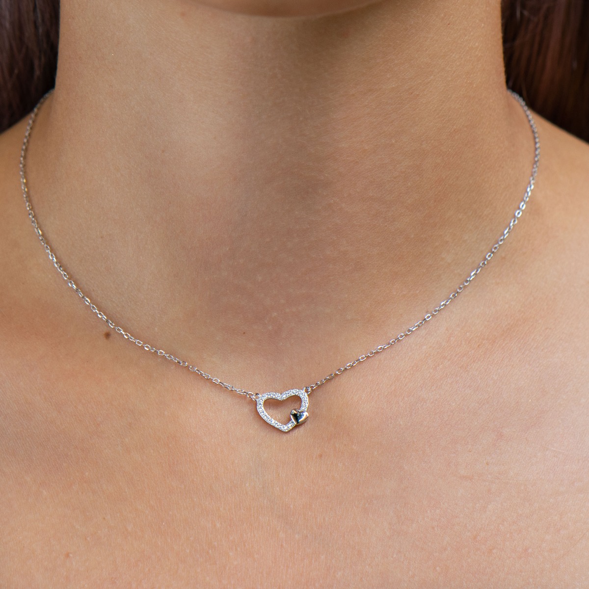 Tempting creation of women's necklace in fine silver with two hearts and countless sparkling zircons. The jewelry is suitable for romantic ladies and also carries symbolism for expectant mothers carrying the new life under their heart.