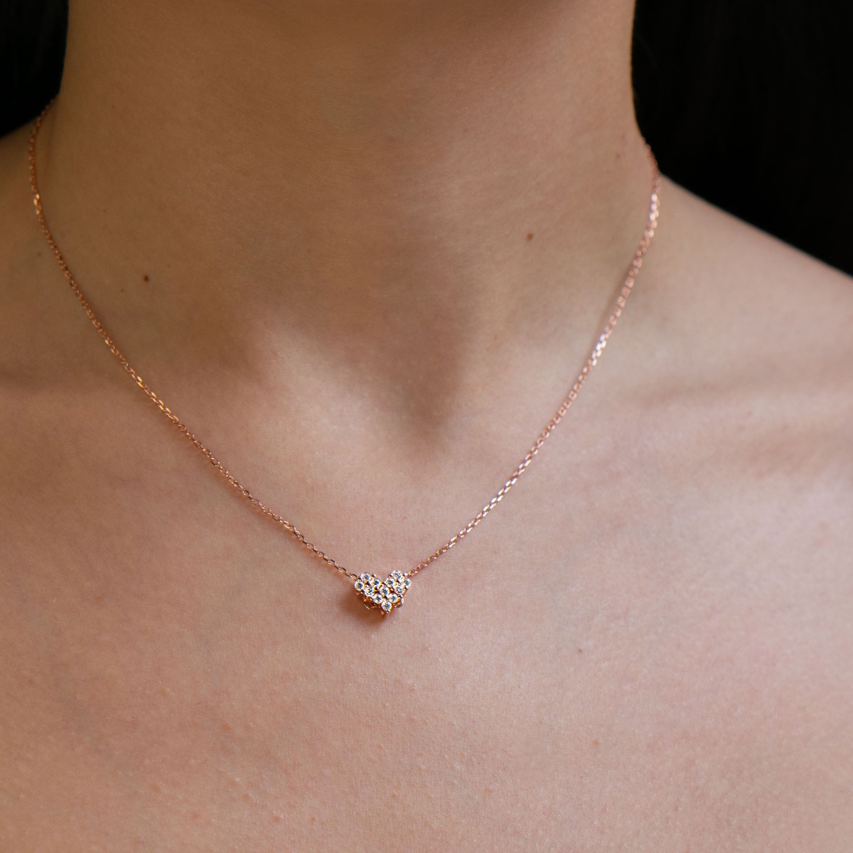 A charming delicate necklace with an elegant heart design, made entirely of fine rose silver and sparkling zircons.