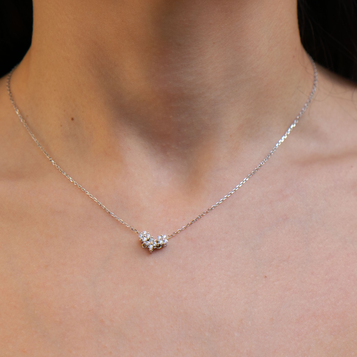 A charming delicate necklace with an abstract heart design, made entirely of fine silver and sparkling zircons.