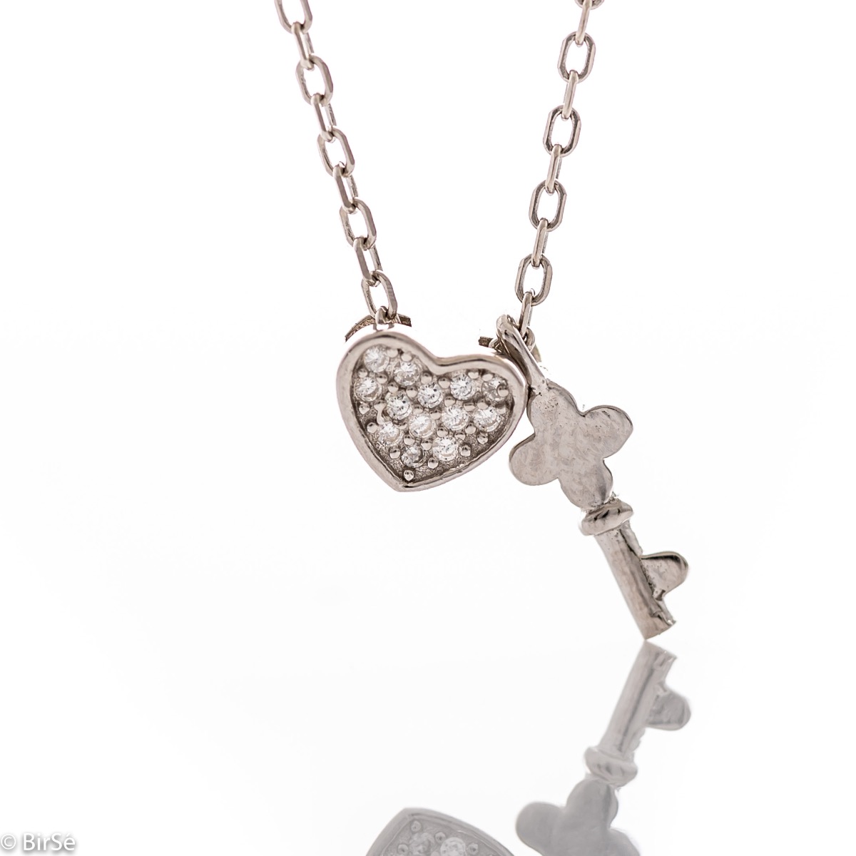 Fine women's necklace in the shape of a delicate heart with sparkling zircons, accompanied by a small key and made entirely of rhodium-plated silver.