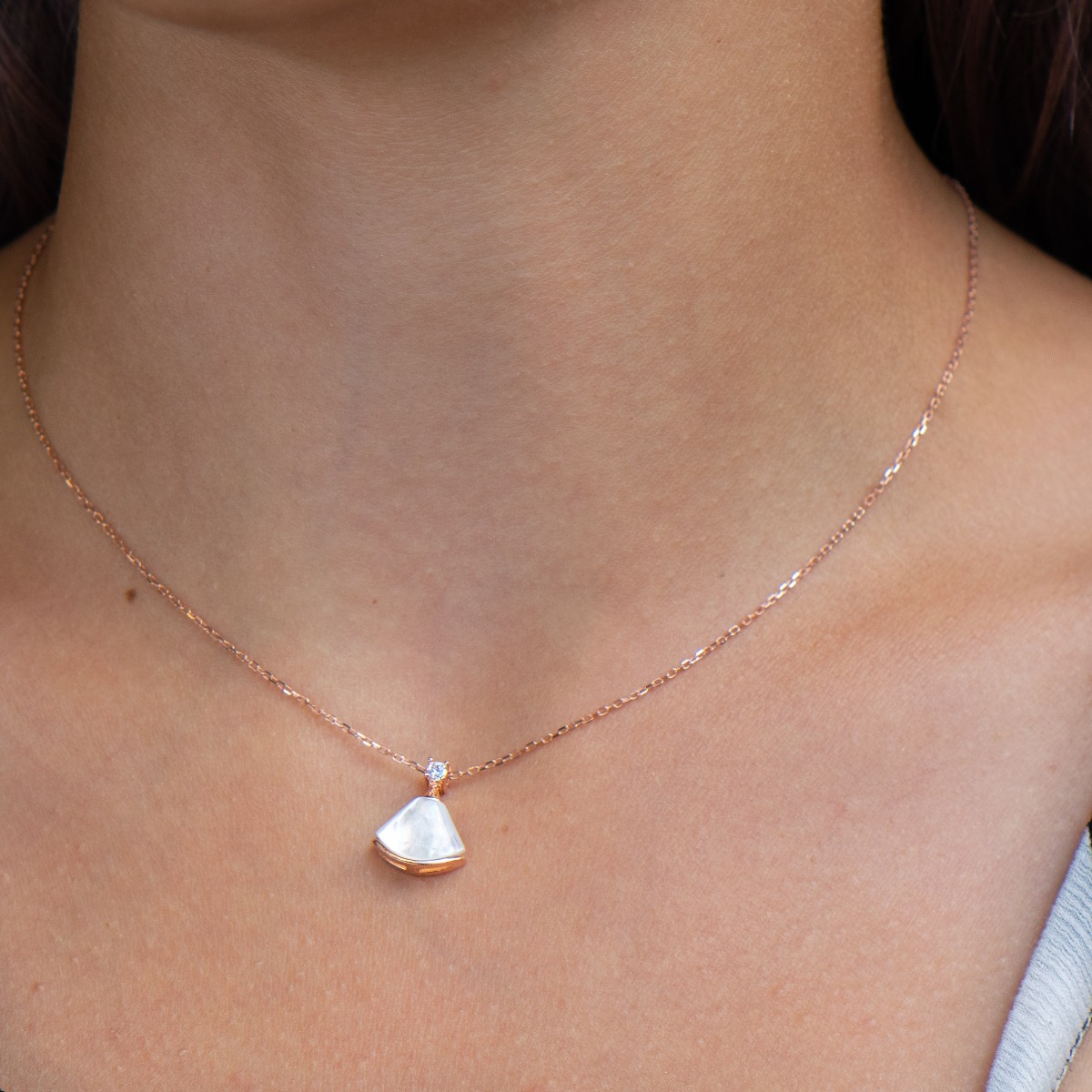 A charming delicate necklace with an elegant design, made entirely of fine rose silver and beautiful mother-of-pearl. A dainty zircon is added to complete the perfection.