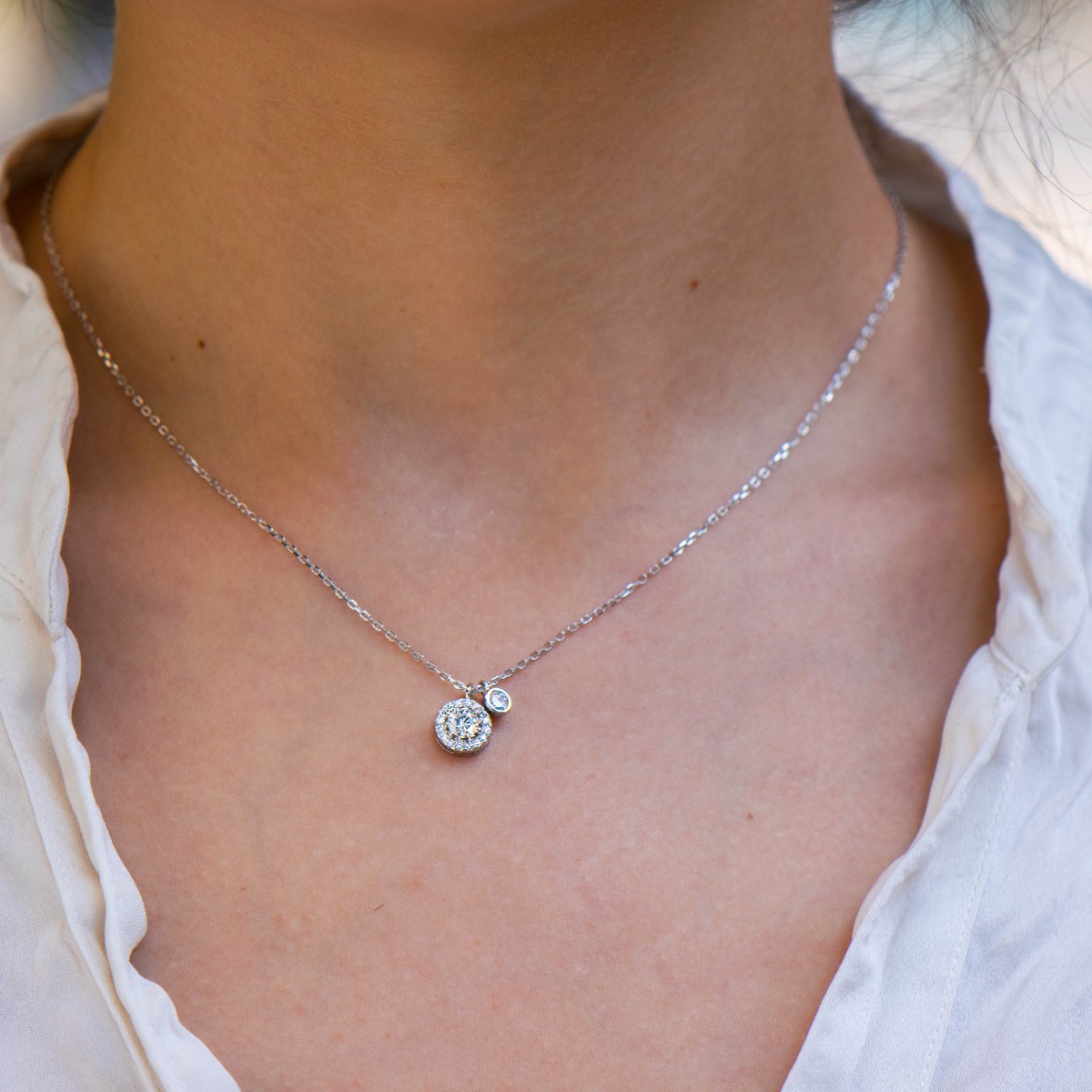 Stylish women's necklace made of shiny rhodium silver with an elegant element, exquisitely decorated with zircons.