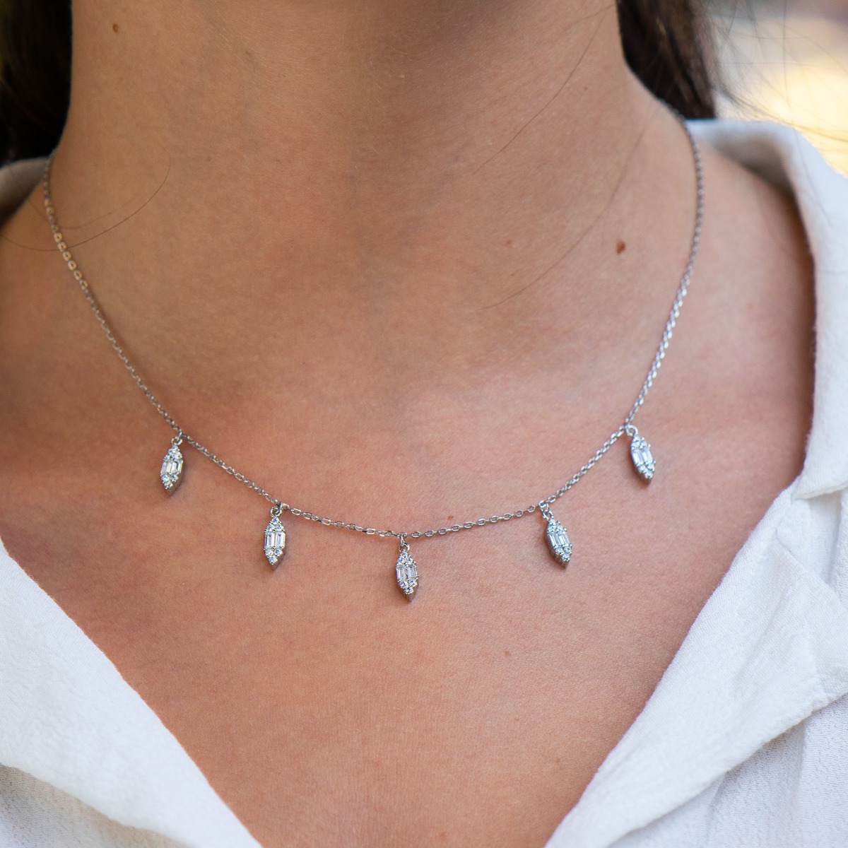 Exquisitely crafted women's necklace of fine rhodium silver, with beautifully shaped pendants of sparkling zircons. The jewelry is suitable for any lady's casual or formal outfit.