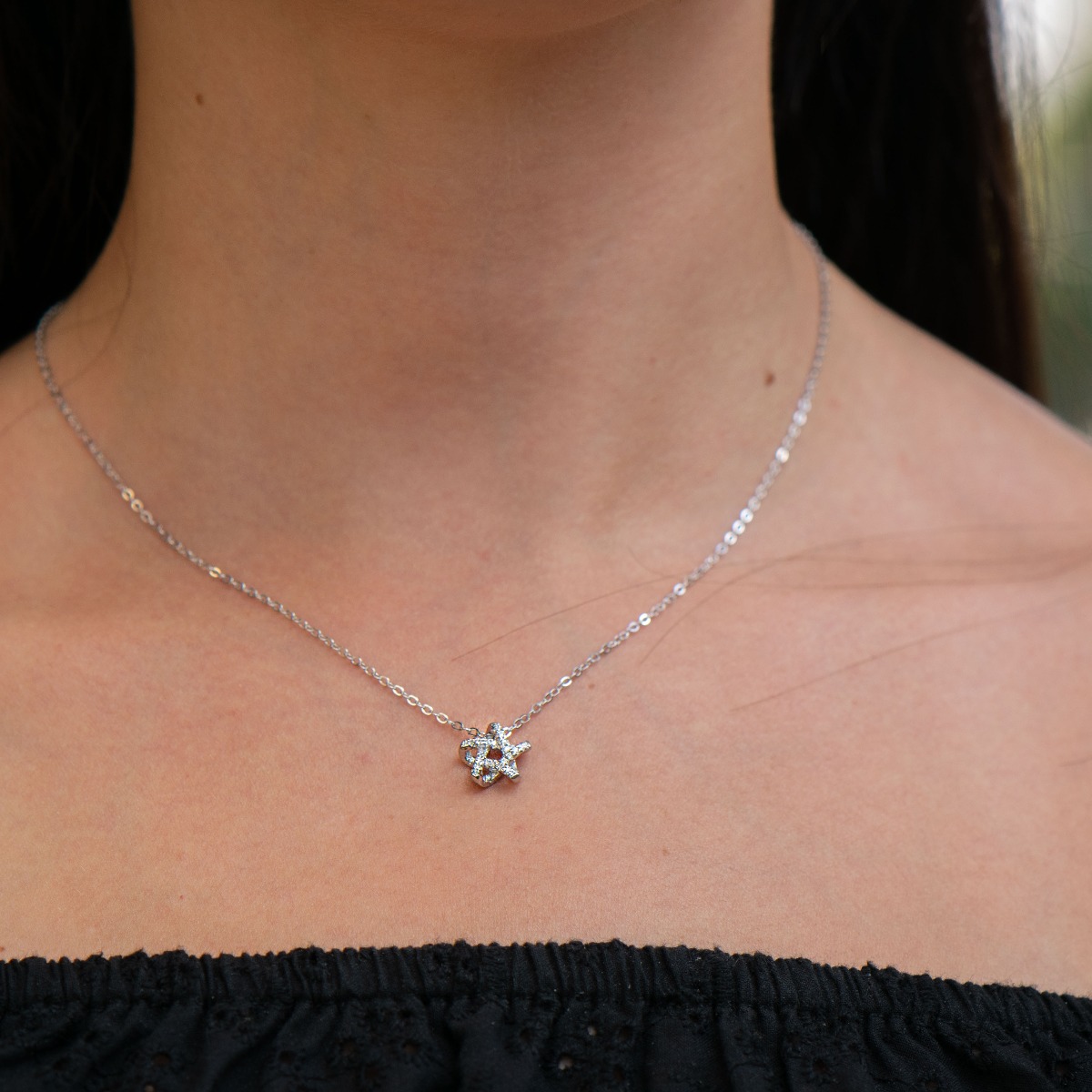 An elegant silver necklace with an accent of a spectacularly shaped star. Stylish composition made entirely of soft rhodium-plated silver, enhanced by the shine of white zircons.