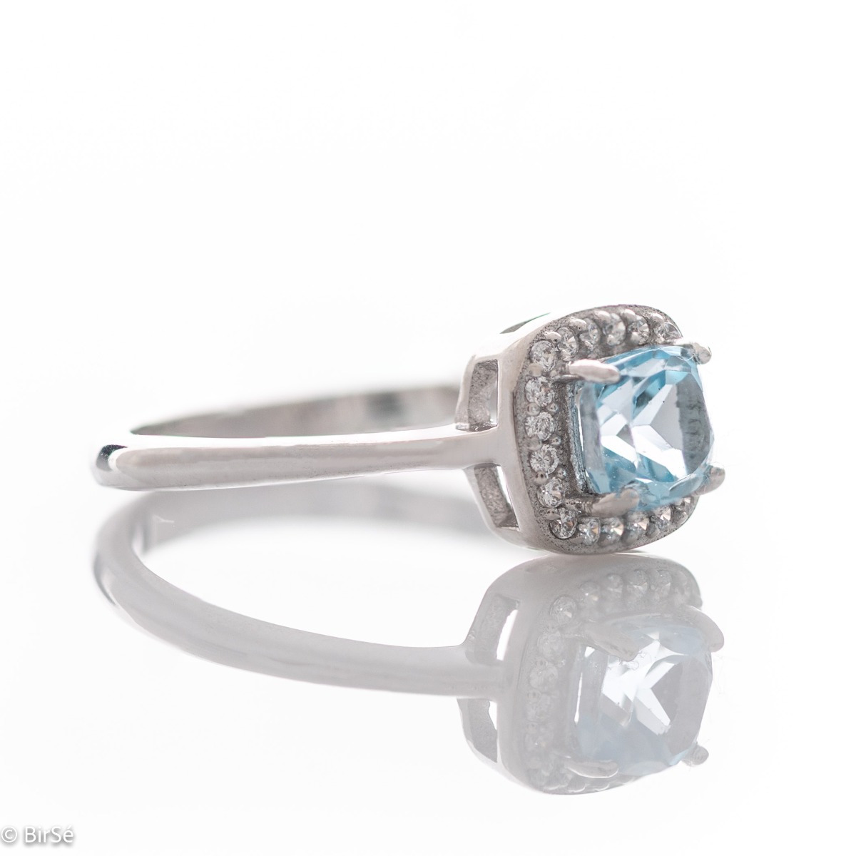 Tempting ring of rhodium-plated silver and natural blue topaz in the exquisite embrace of zircon stones.