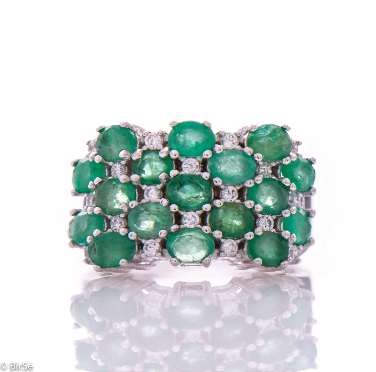 Women's ring with modern craftsmanship, combining numerous fine natural emerald stones, complemented by the sparkle of zircons and made entirely of rhodium-plated silver. In a charming set with matching necklace and earrings.