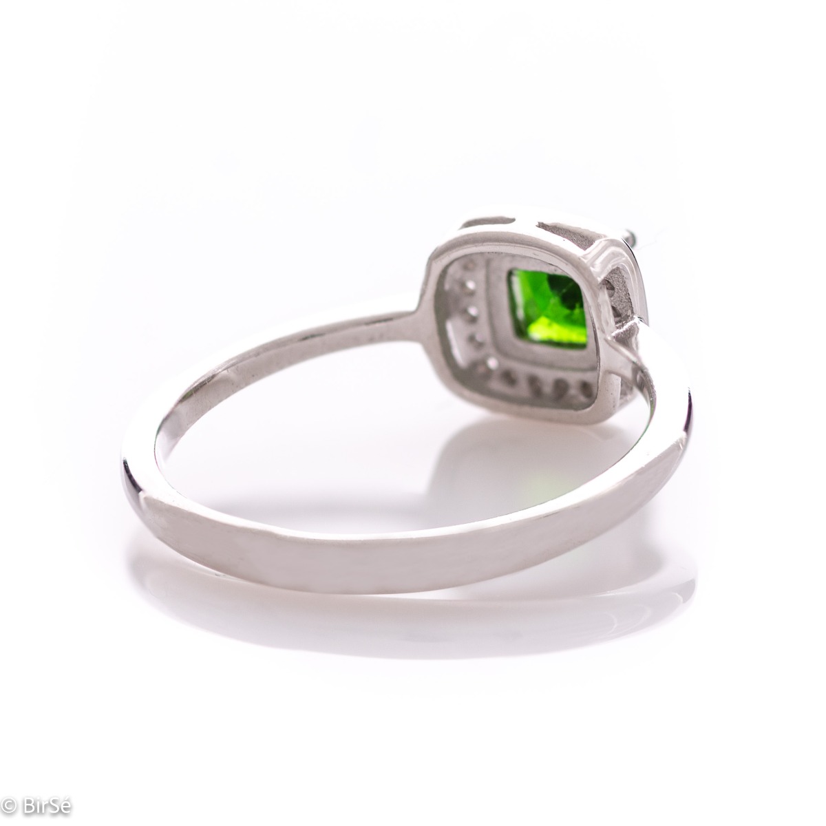 An elegant ring with precise craftsmanship from soft rhodium-plated silver. At the center of the jewel is set a mesmerizing green Chrome Diopside stone in the company of sparkling zircons. Part of a sophisticated set including a pendant and stud earrings.