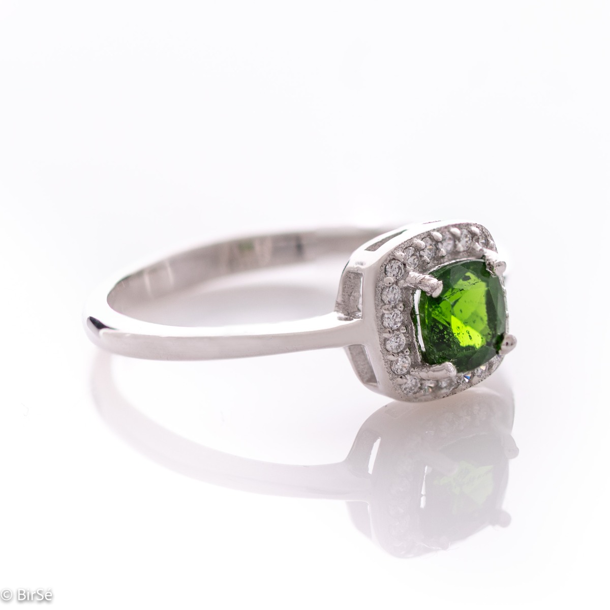 An elegant ring with precise craftsmanship from soft rhodium-plated silver. At the center of the jewel is set a mesmerizing green Chrome Diopside stone in the company of sparkling zircons. Part of a sophisticated set including a pendant and stud earrings.