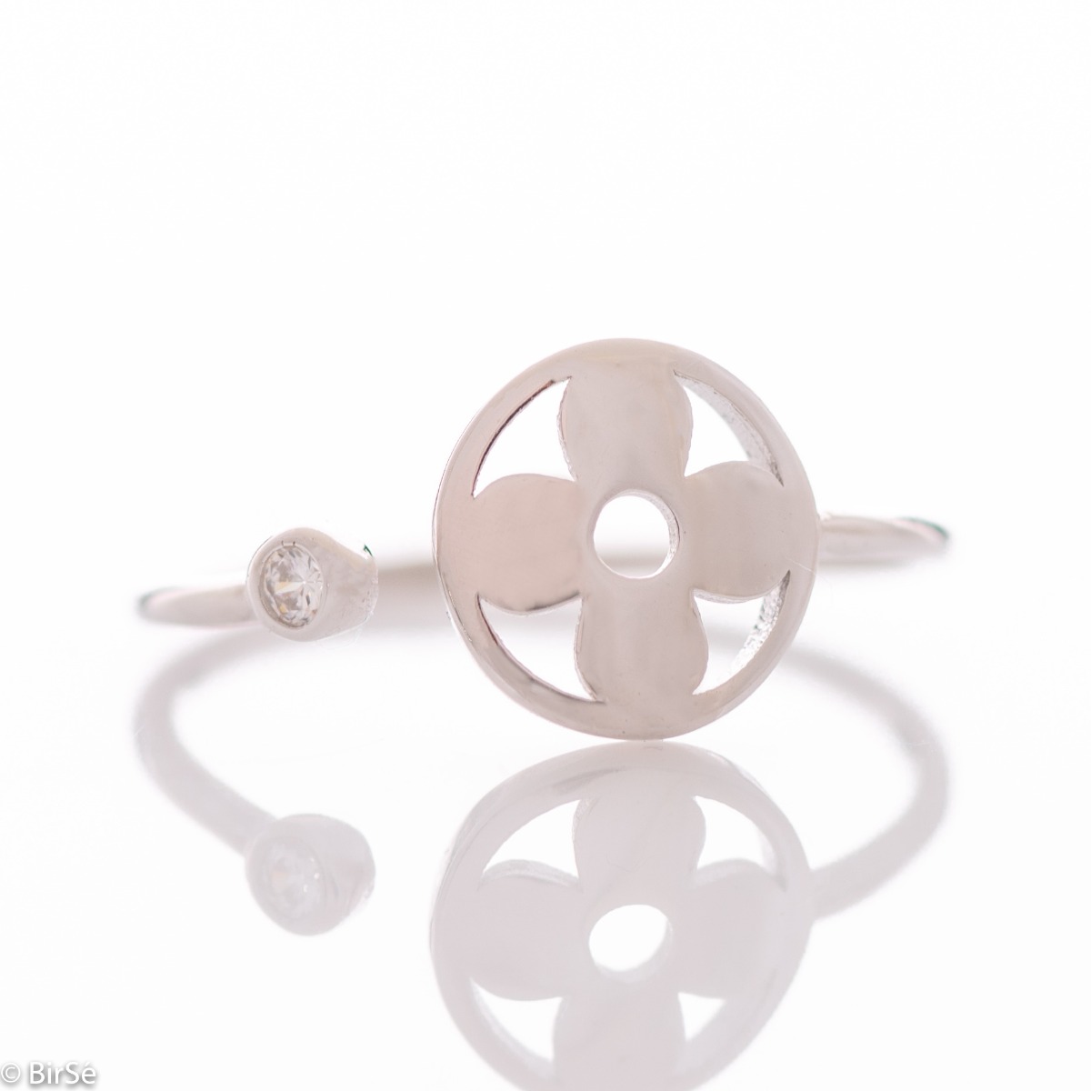 Beautifully crafted ring in sterling silver, adjustable pattern, ending at one end with a round element in the middle with a flower. At the other end, in a delicate fitting, a tiny zircon sparkles beautifully.