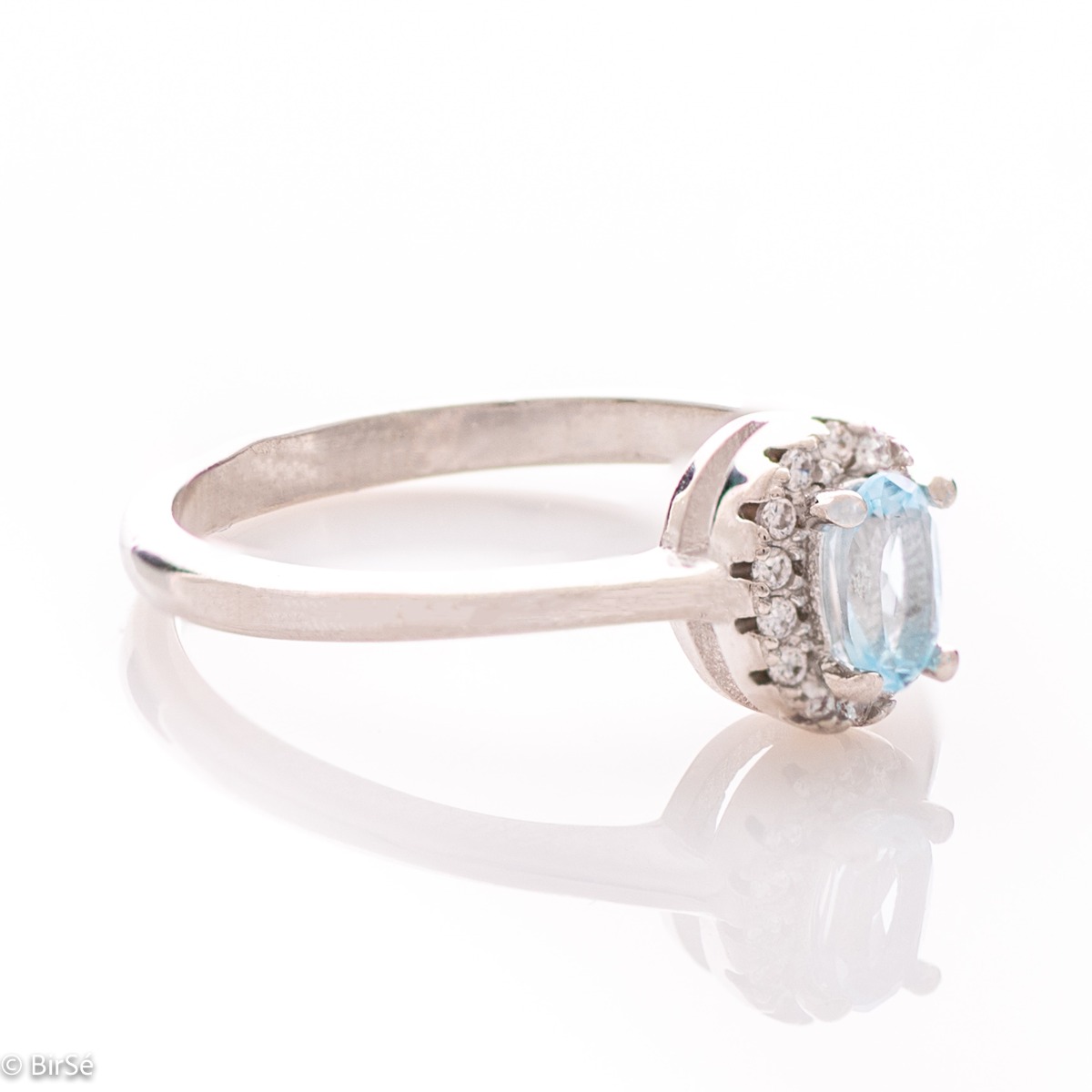 An exquisite women's ring with a tempting natural blue topaz, complemented by the sparkle of fine cubic zirconias and beautifully crafted entirely in rhodium-plated silver. In a charming set with matching earrings, bracelet and necklace.