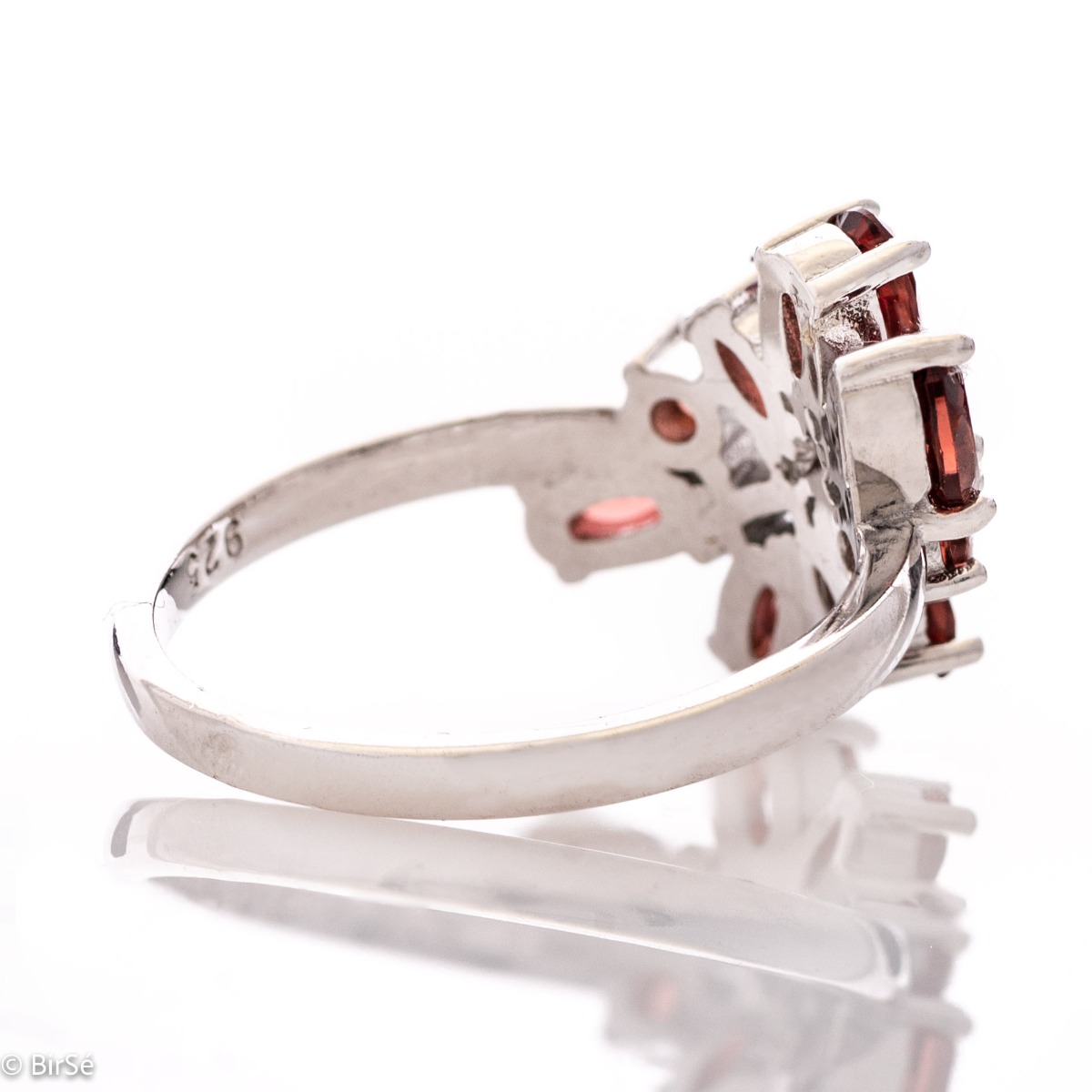 Delicately elegant silver ring with a charming look and innovative design. Stylish craftsmanship from a fine combination of rhodium-plated silver with charming natural garnet stones and delicate zircons.