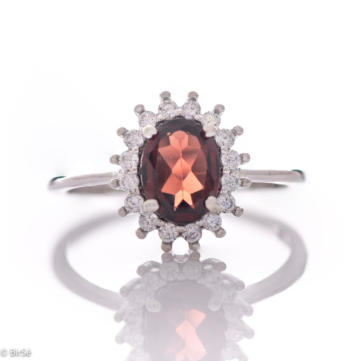 An elegant women's ring with a spectacular workmanship entirely of rhodium-plated silver, combined with a radiant natural garnet and sparkling zircons. Can be combined with earrings and pendant of the same model.