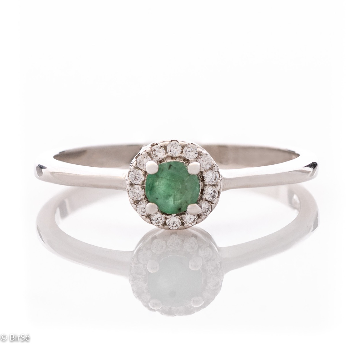 Delicate emerald shine - an extremely beautiful ladies ring with a round shape. Stylish craftsmanship from a fine combination of rhodium silver, fine emerald and sparkling zircons.