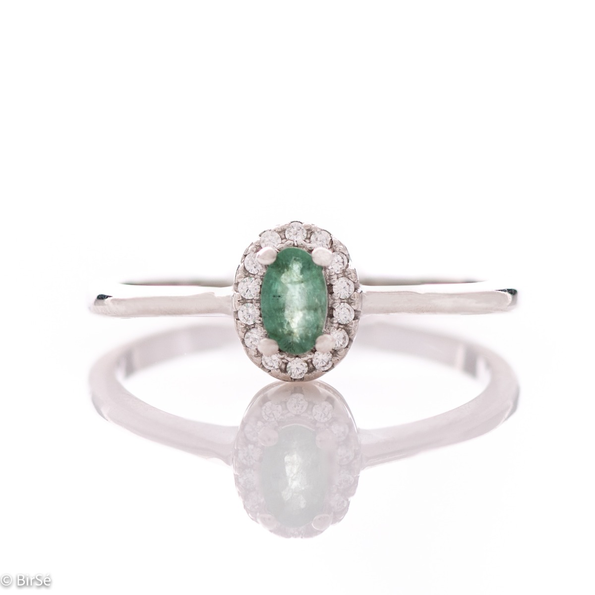 An elegant women's ring with a delicate natural emerald stone, complemented by the sparkle of fine zircons and beautiful craftsmanship entirely in rhodium-plated silver. In a charming set with matching earrings, bracelet and necklace.