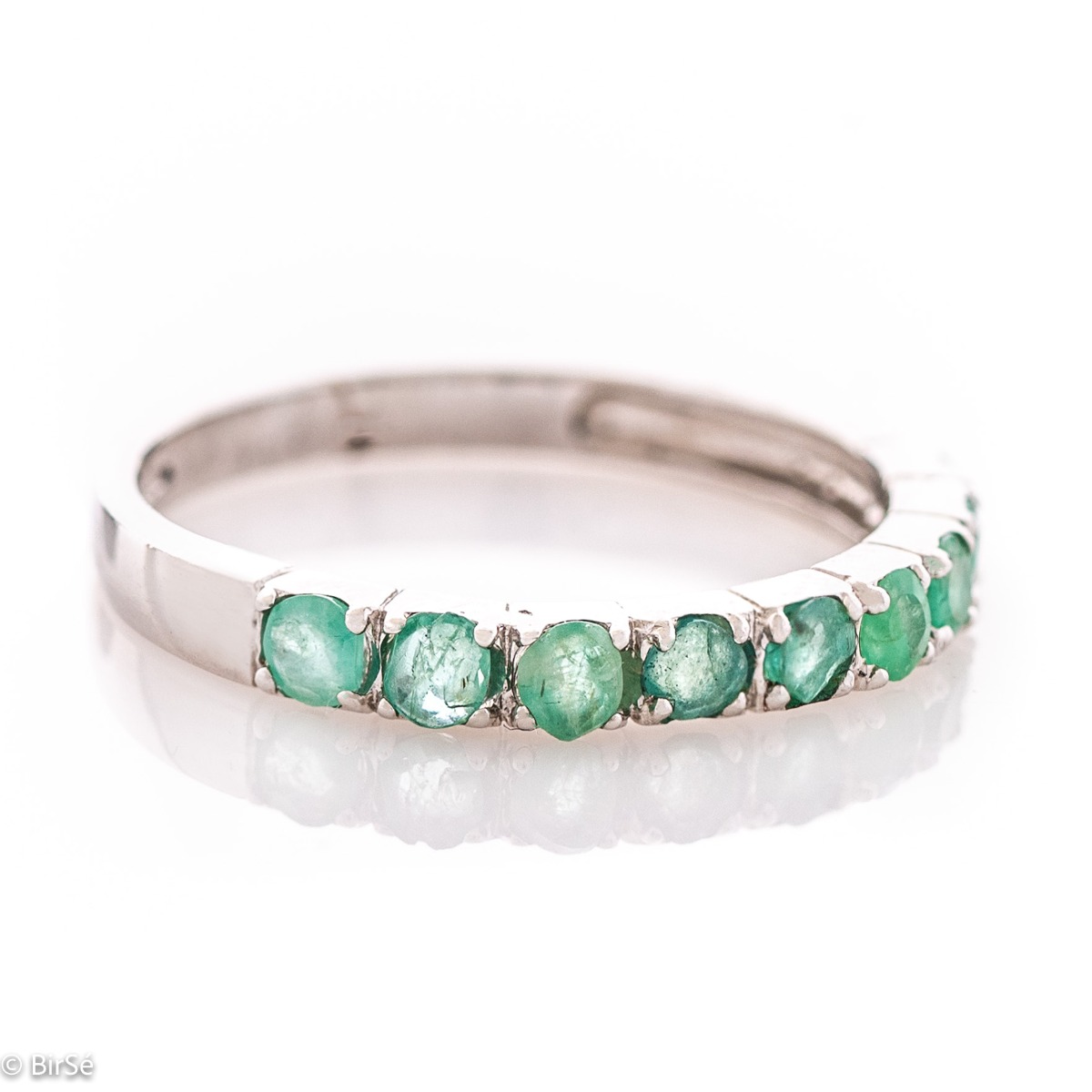 Finely crafted fine rhodium silver women's ring with a row of charming natural emeralds.