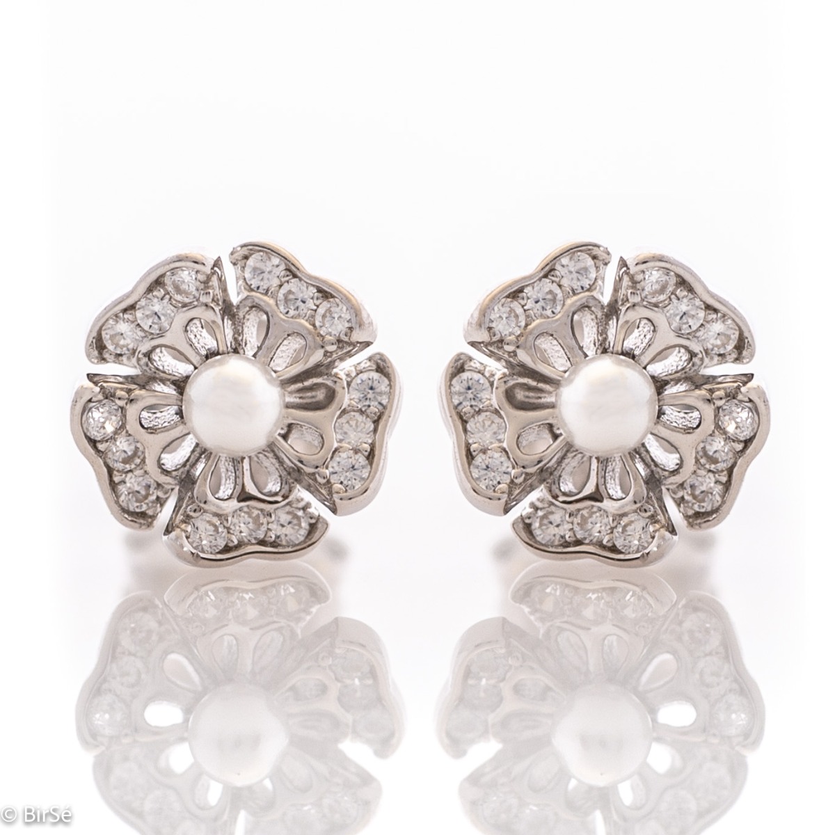 Charming flower shaped soft rhodium silver stud earrings encrusted with zircons and a charming pearl in the center. Pin fastening is comfortable and secure for little and big ladies.