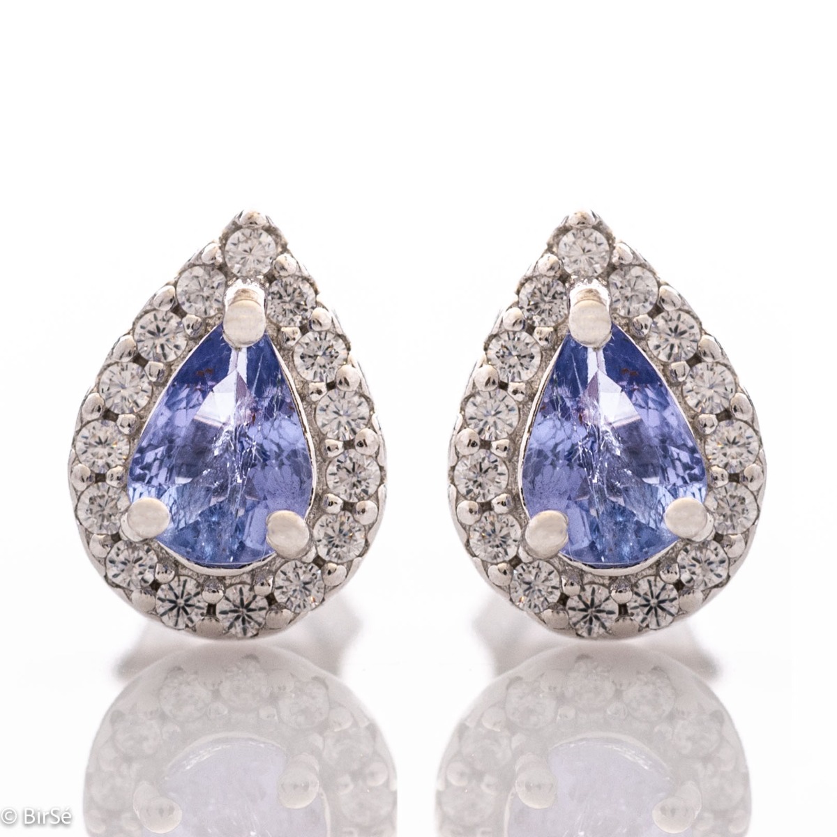 Elegant women's stud earrings with delicate drop-shaped natural tanzanite surrounded by sparkling zircons and exquisitely crafted in beautiful rhodium silver. In a charming ring, necklace and bracelet set.