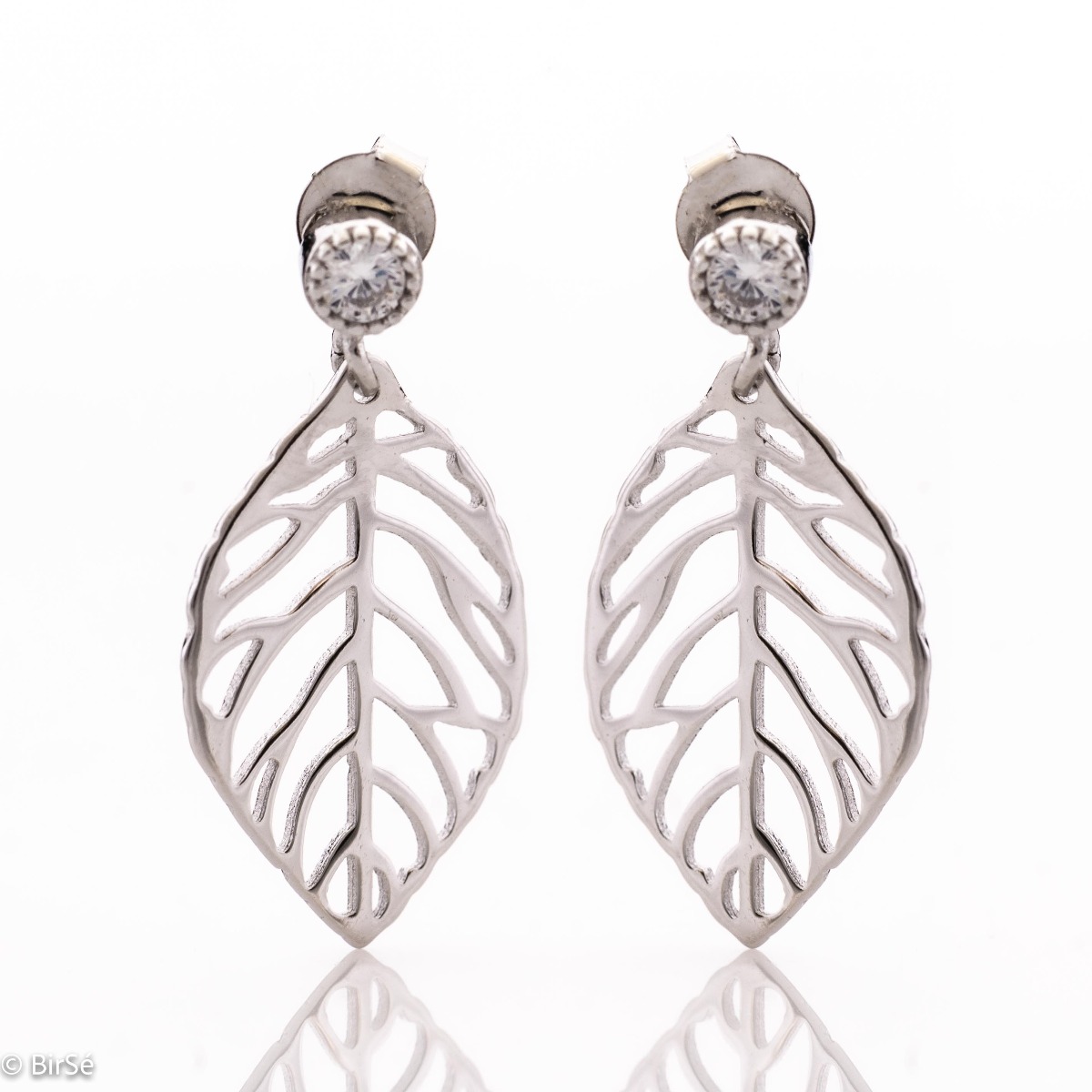 Delicately elegant silver earrings in the form of a leaf with a pin fastening. Stylish composition made of fine combination of rhodium silver with sparkling zircon. Suitable for combining with silver leaf-shaped necklaces.