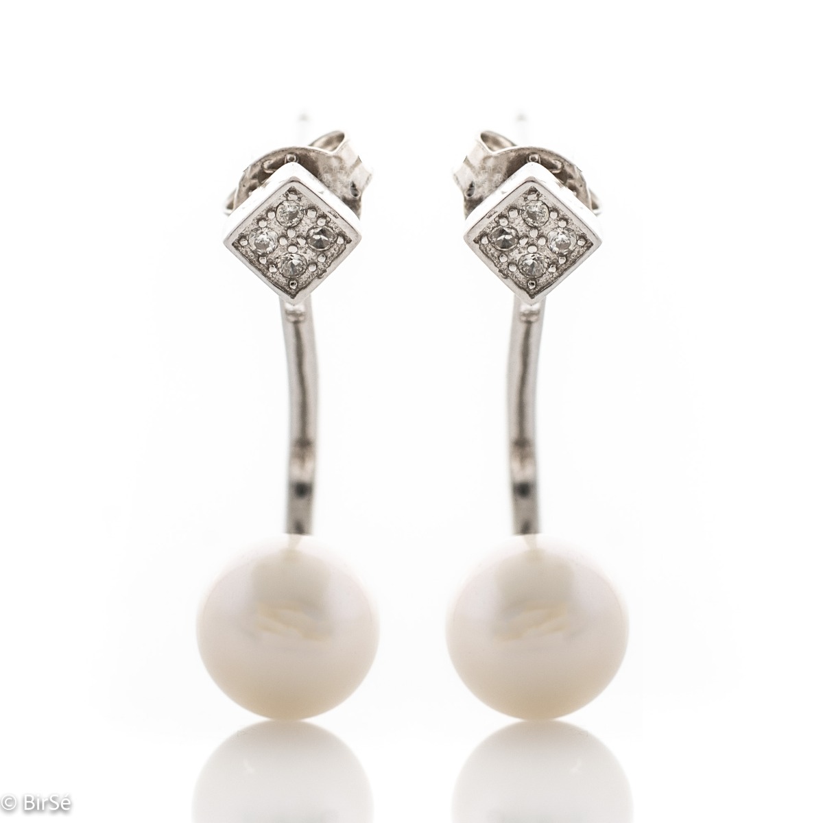 A beautiful model of women's earrings, entirely made of fine rhodium silver, with a comfortable and secure pin fastening. Delicate, sparkling zircons adorn the earpiece, while a fine pearl elegantly protrudes below. Charming and suitable for any occasion.