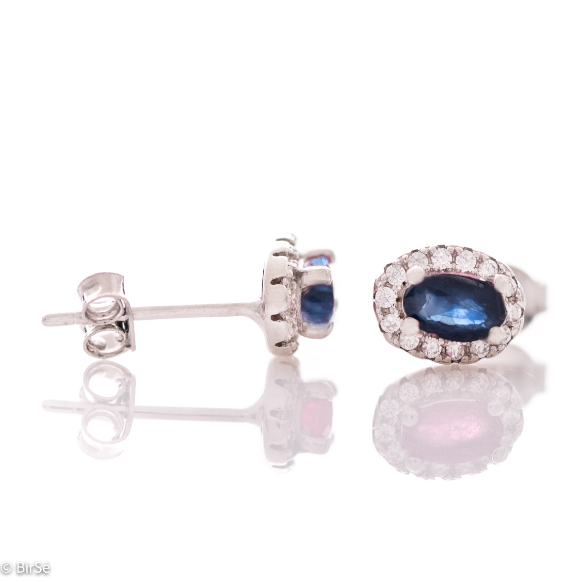 Stylish women's earrings with an elegantly shaped pattern of rhodium-plated silver and a natural sapphire stone, beautifully surrounded by dazzling zircons.