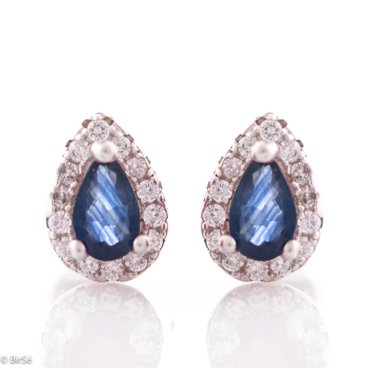 Elegant women's stud earrings with a delicate drop-shaped natural sapphire, surrounded by sparkling zircons and exquisitely crafted in beautiful rhodium-plated silver. In a charming ring, necklace and bracelet set.