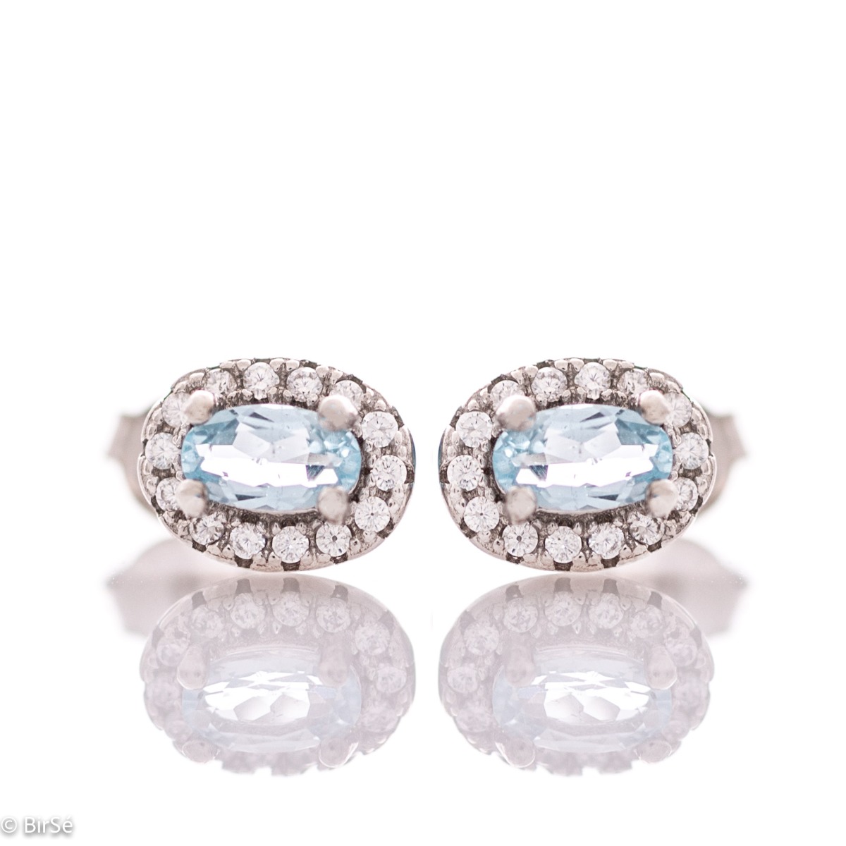 Stylish women's earrings with an elegantly shaped rhodium silver pattern and a magical blue topaz, beautifully surrounded by dazzling zircons.