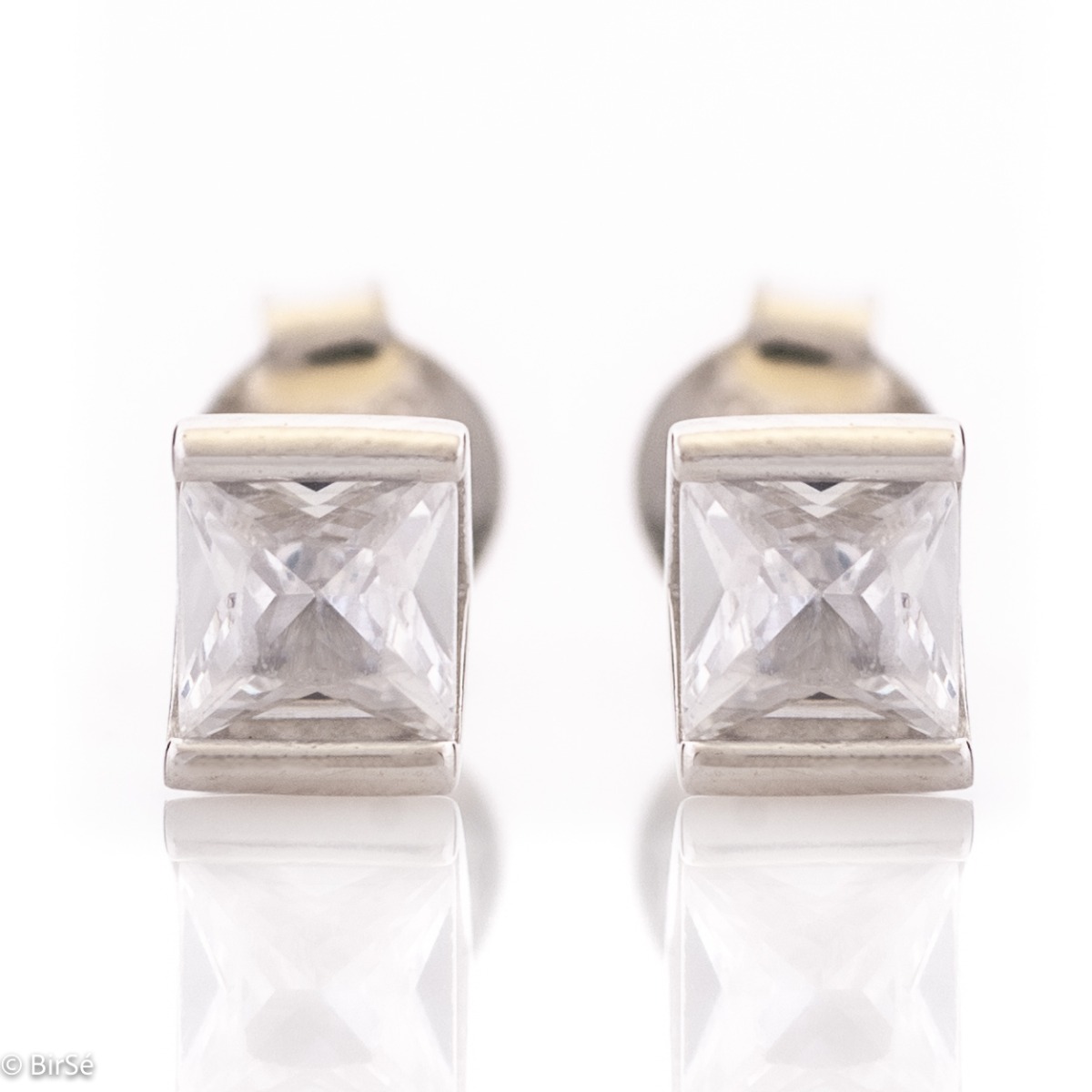 Simply shaped ladies' earrings, made with a rectangular shape entirely of rhodium-plated silver. A charming zircon is the main character in this jewelry performance, undisturbed by any additional elements. The fastening is with a pin - comfortable and sec