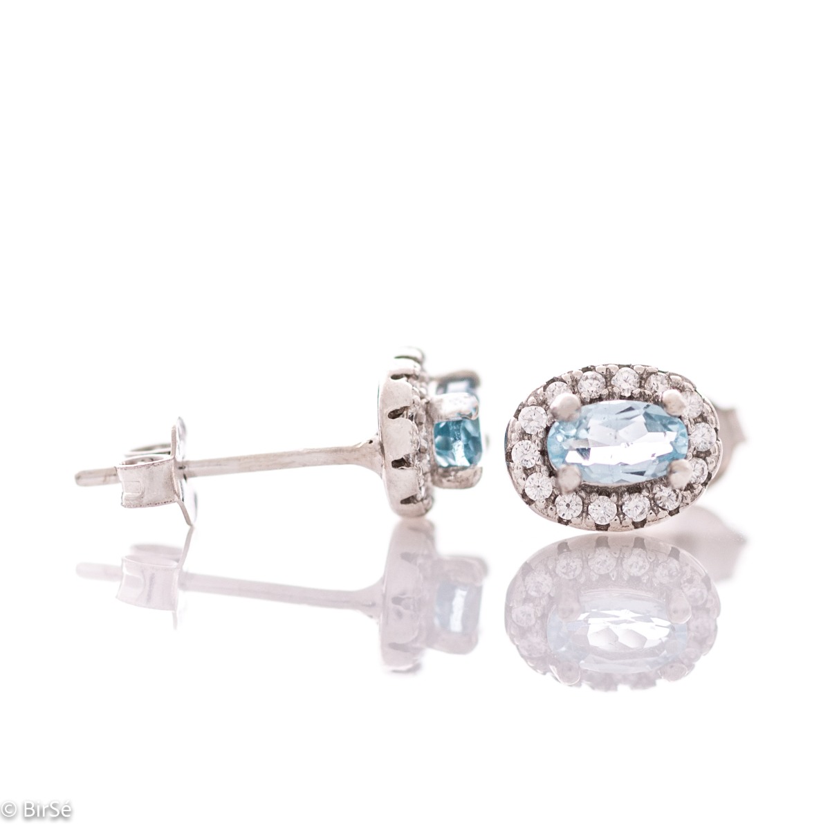 Stylish women's earrings with an elegantly shaped rhodium silver pattern and a magical blue topaz, beautifully surrounded by dazzling zircons.