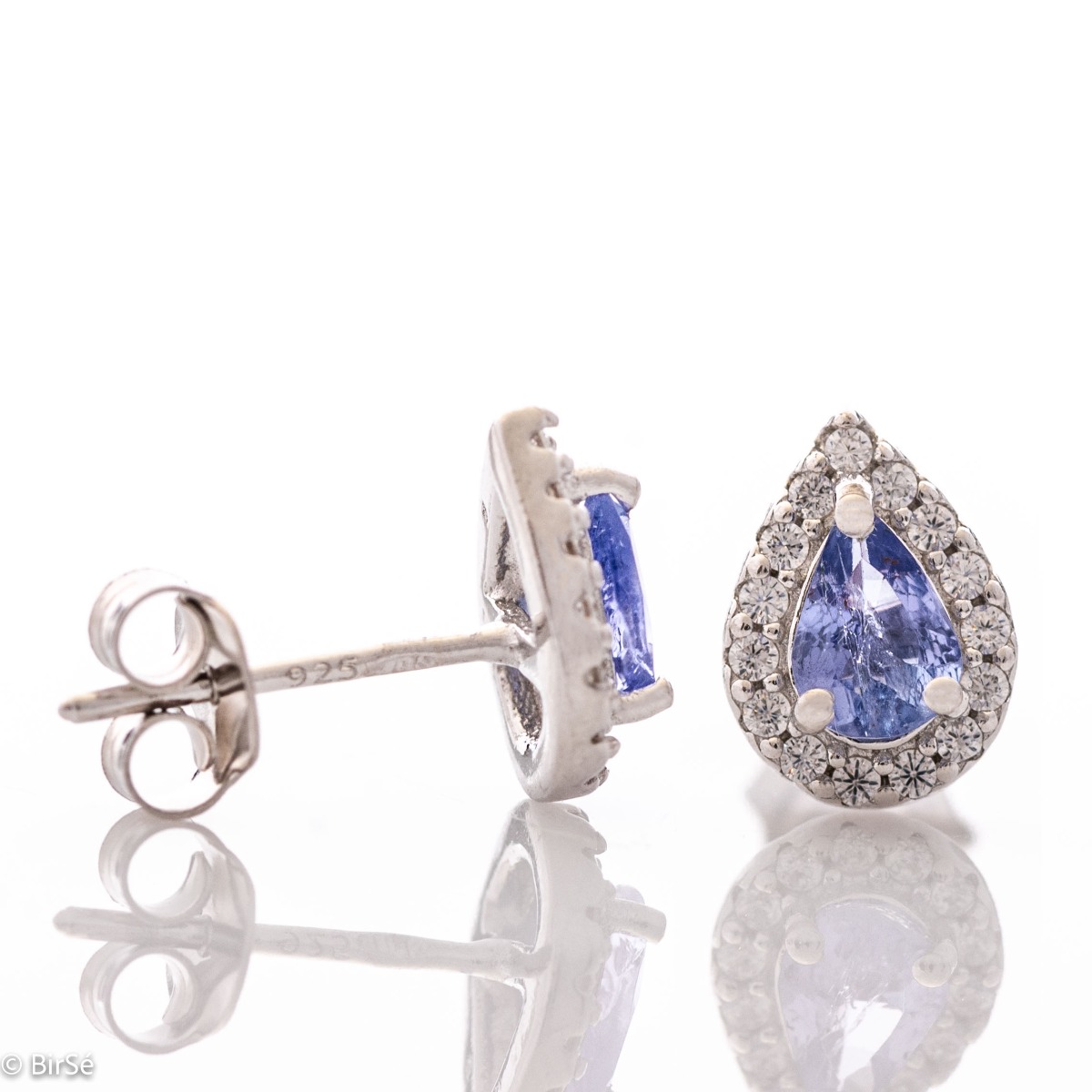 Elegant women's stud earrings with delicate drop-shaped natural tanzanite surrounded by sparkling zircons and exquisitely crafted in beautiful rhodium silver. In a charming ring, necklace and bracelet set.