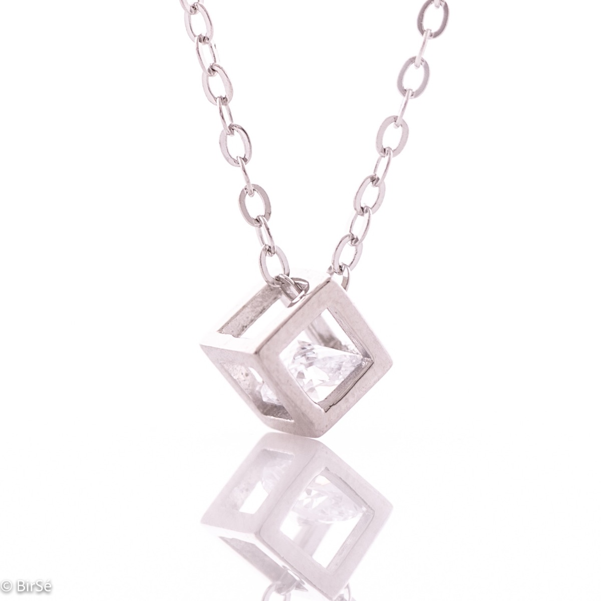 A stylish women's necklace made of sparkling rhodium silver with an elegant cube-shaped pendant, in the center of which a dazzling zircon mystically sparkles.