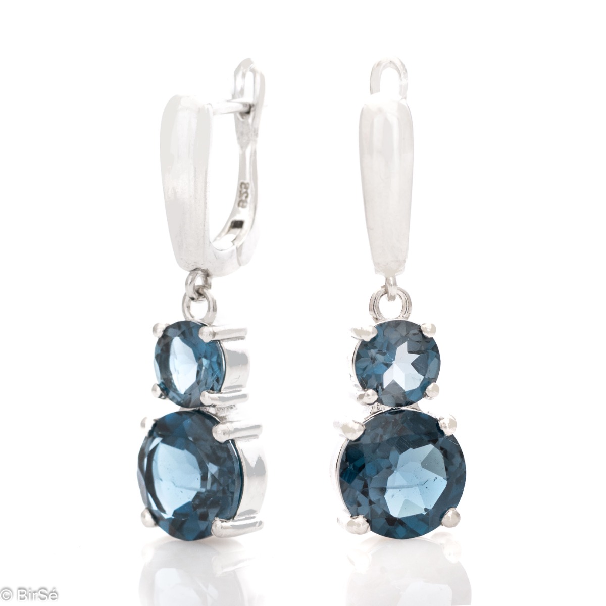 Delicate dangling earrings with an interesting design and radiant natural London topaz. They are made entirely of beautiful rhodium silver with a comfortable English clasp. A spectacular ring and pendant complete the set.